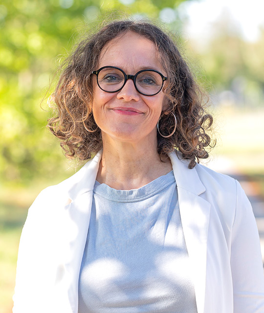 Eine Frau lächelt in die Kamera. Sie ist die Geschäftsführung einer Kommunikationsagentur. 