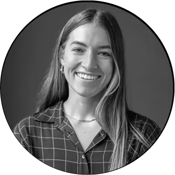 A woman with long hair and a plaid shirt smiling for the camera.