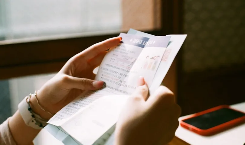A woman is holding a piece of paper.