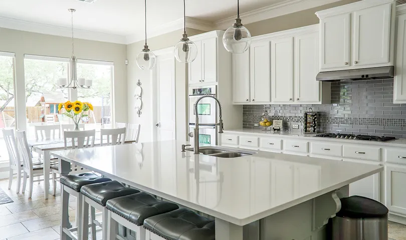 A large kitchen with a center island and white cabinets.