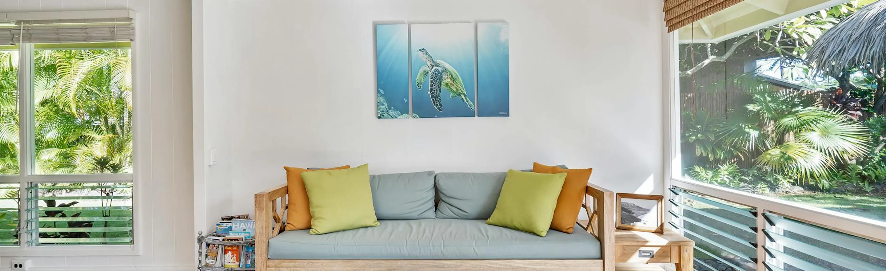 A living room with a couch and a painting on the wall.