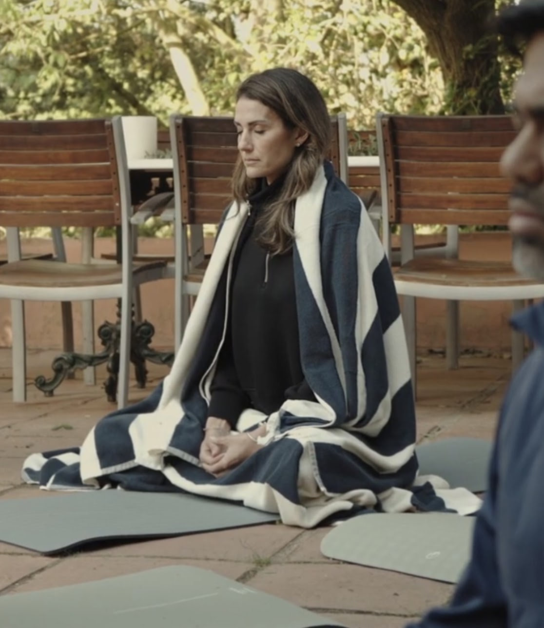 A participant wrapped in a blanket during an outdoor journaling session