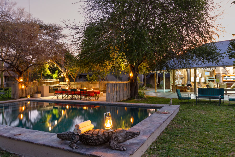 The lodge and pool lit at dusk in the bush