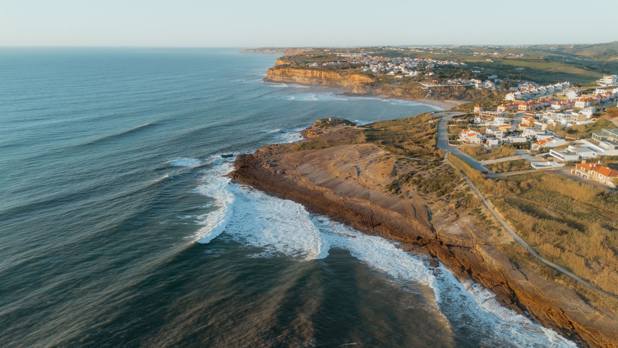 Aerial view of the Atlantic coastline and surf below the village