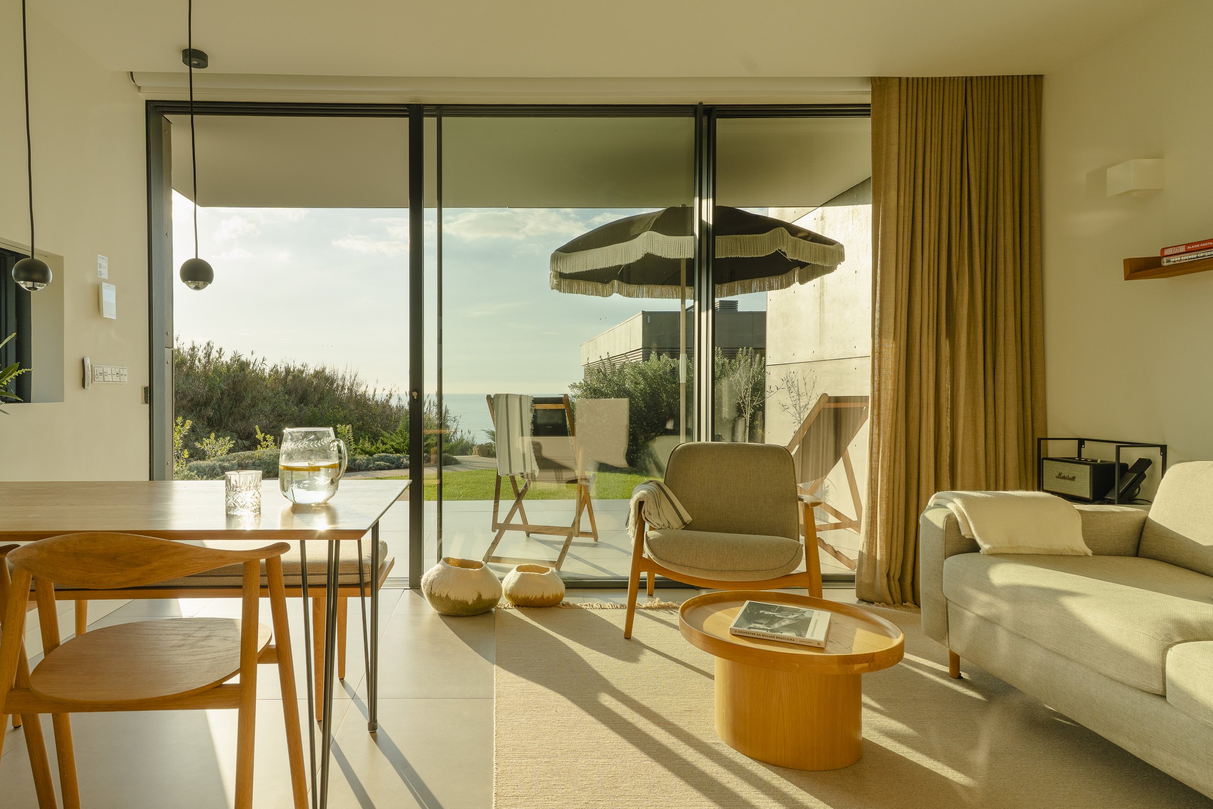 A light-filled hut interior opening onto the terrace and sea