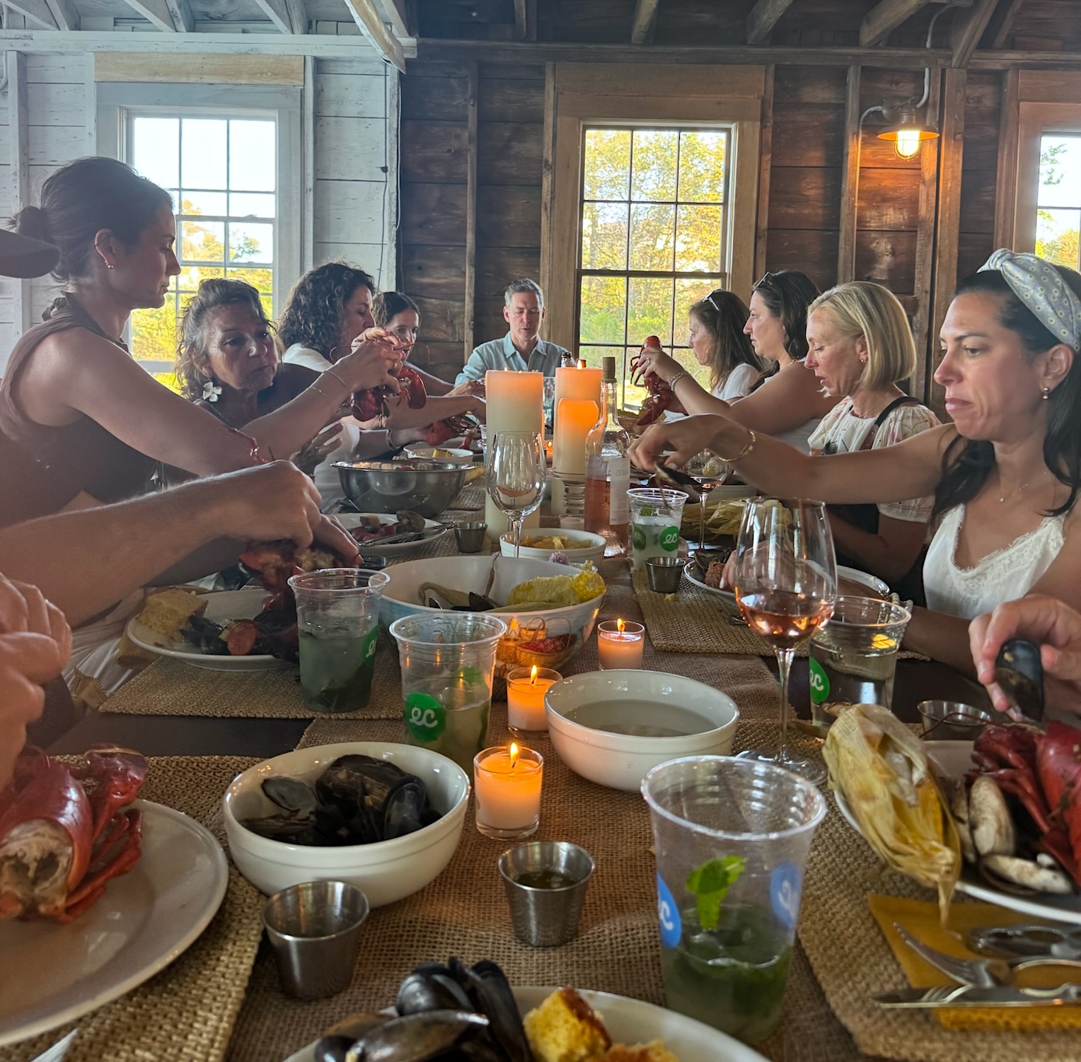 Long communal dinner table with the group raising a toast