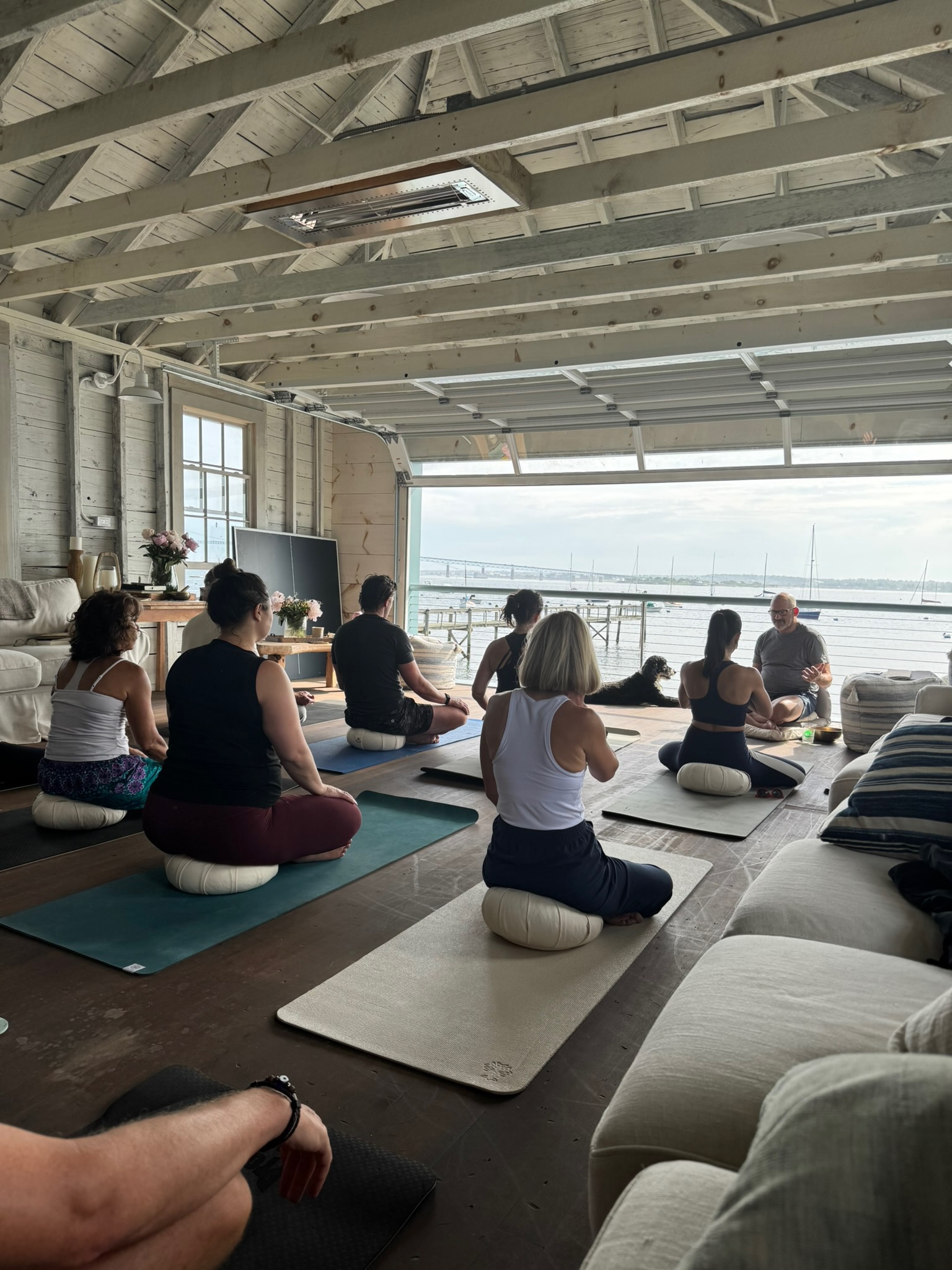 Seated meditation practice on mats facing the water