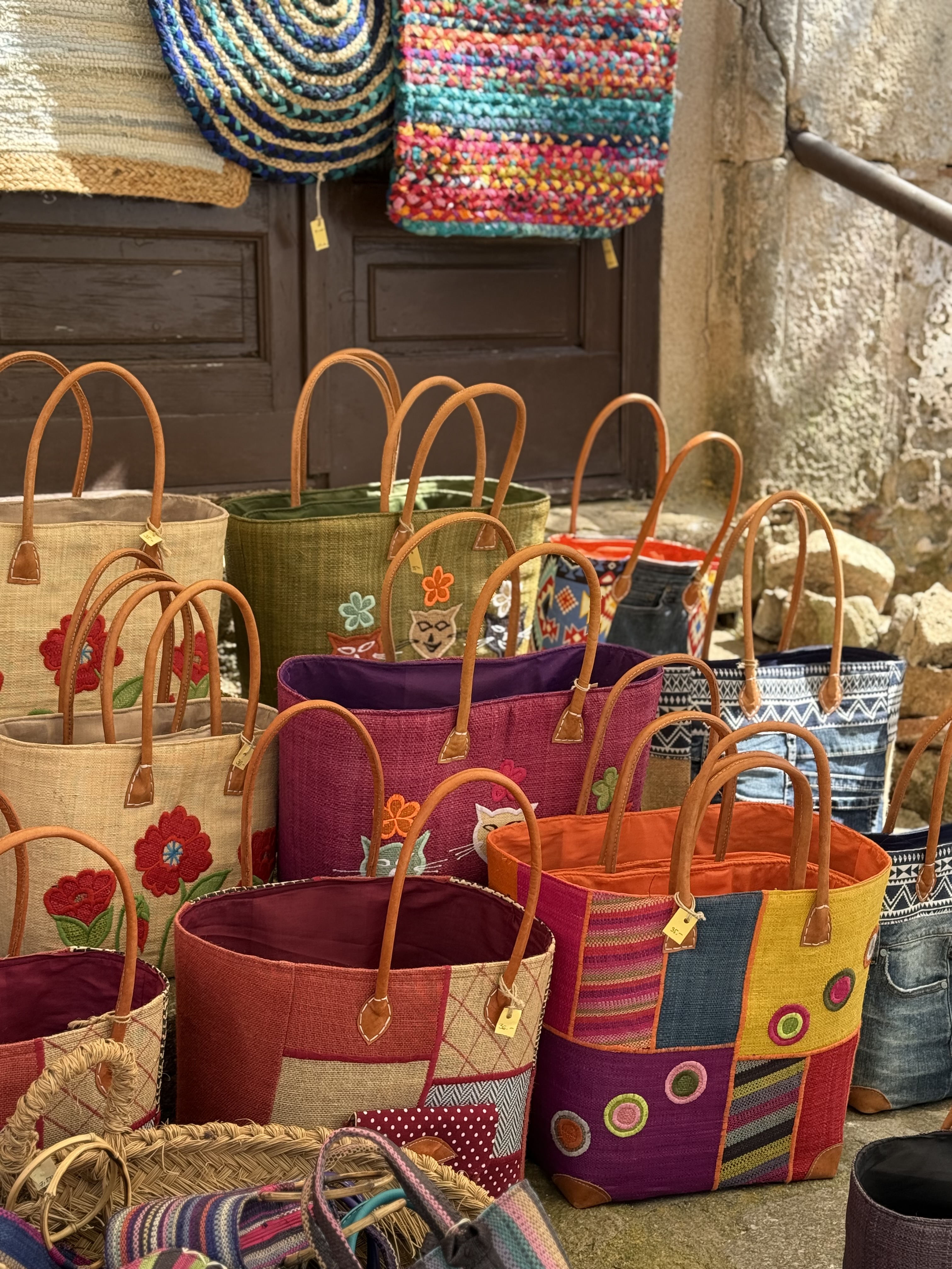 Woven straw market baskets hanging in a shop doorway