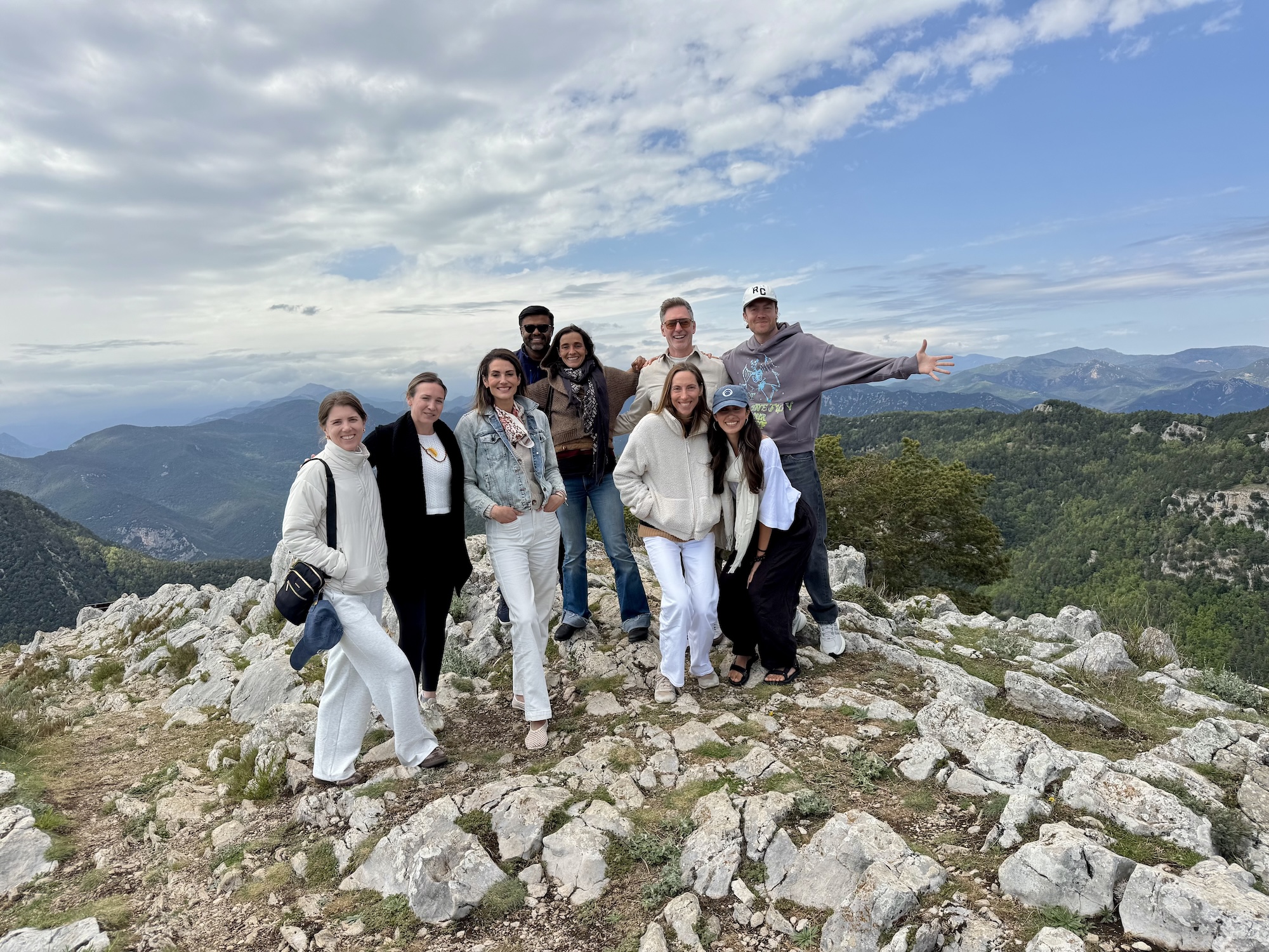 The group on a rocky mountain summit with arms raised