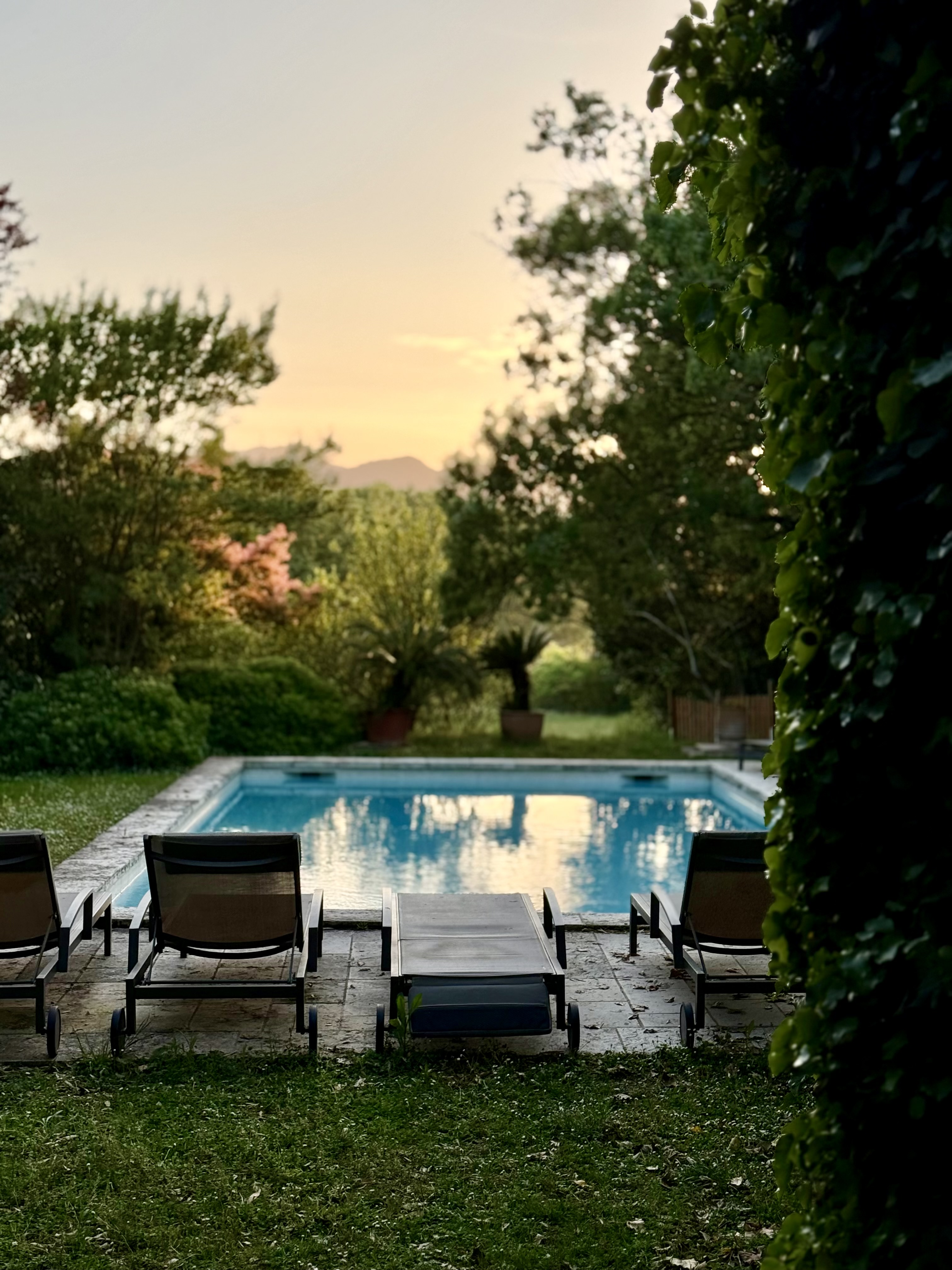 Loungers beside the pool at dusk