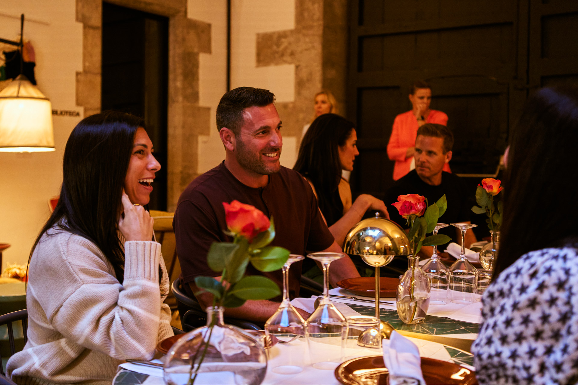 Evening dinner outdoors, guests holding roses at the table
