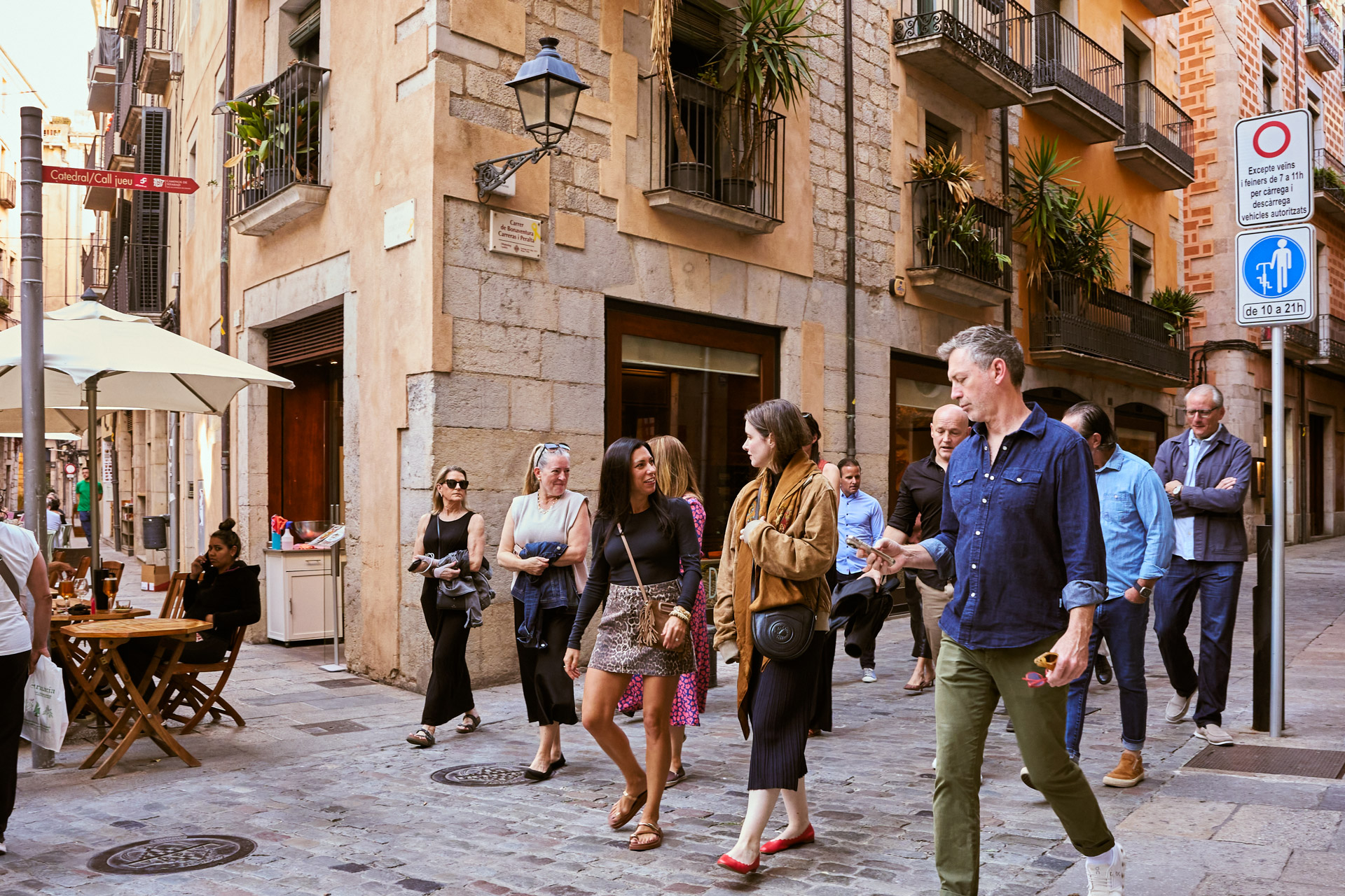 Participants walking through a plaza lined with cafes