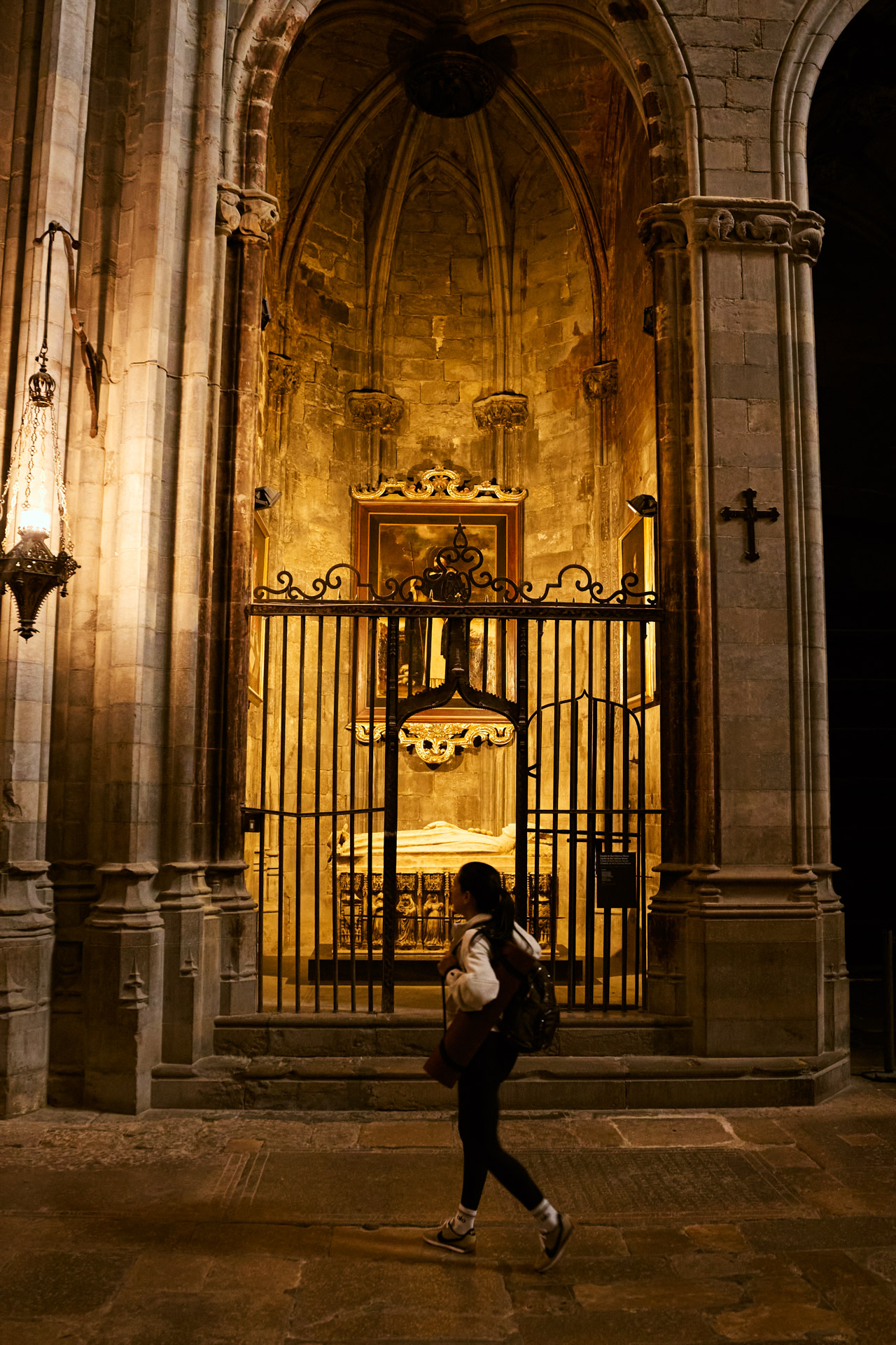 A figure walking through a candlelit church interior