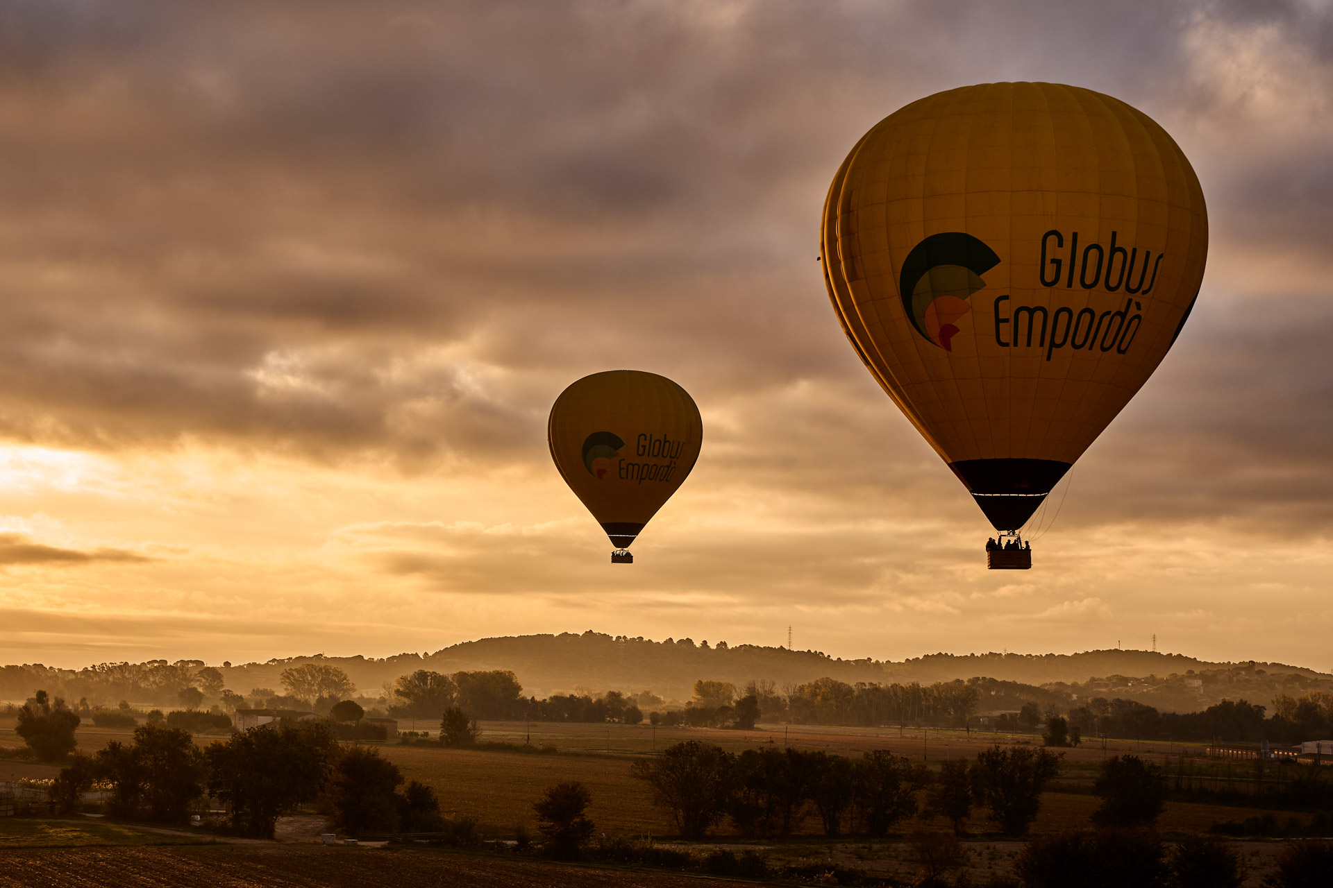Balloons drifting over the Emporda countryside at sunrise