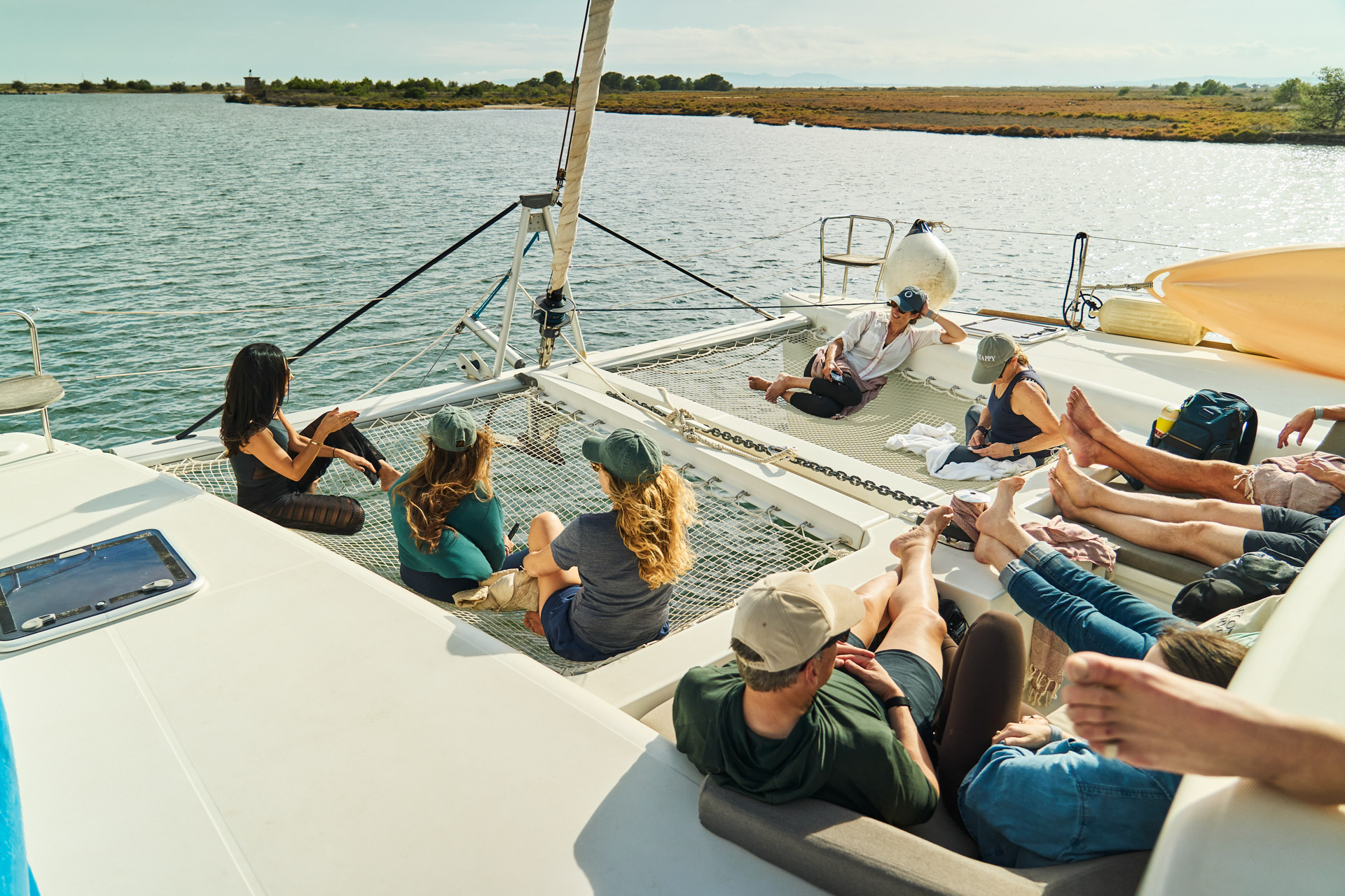 Guests stretched out on the catamaran's foredeck netting