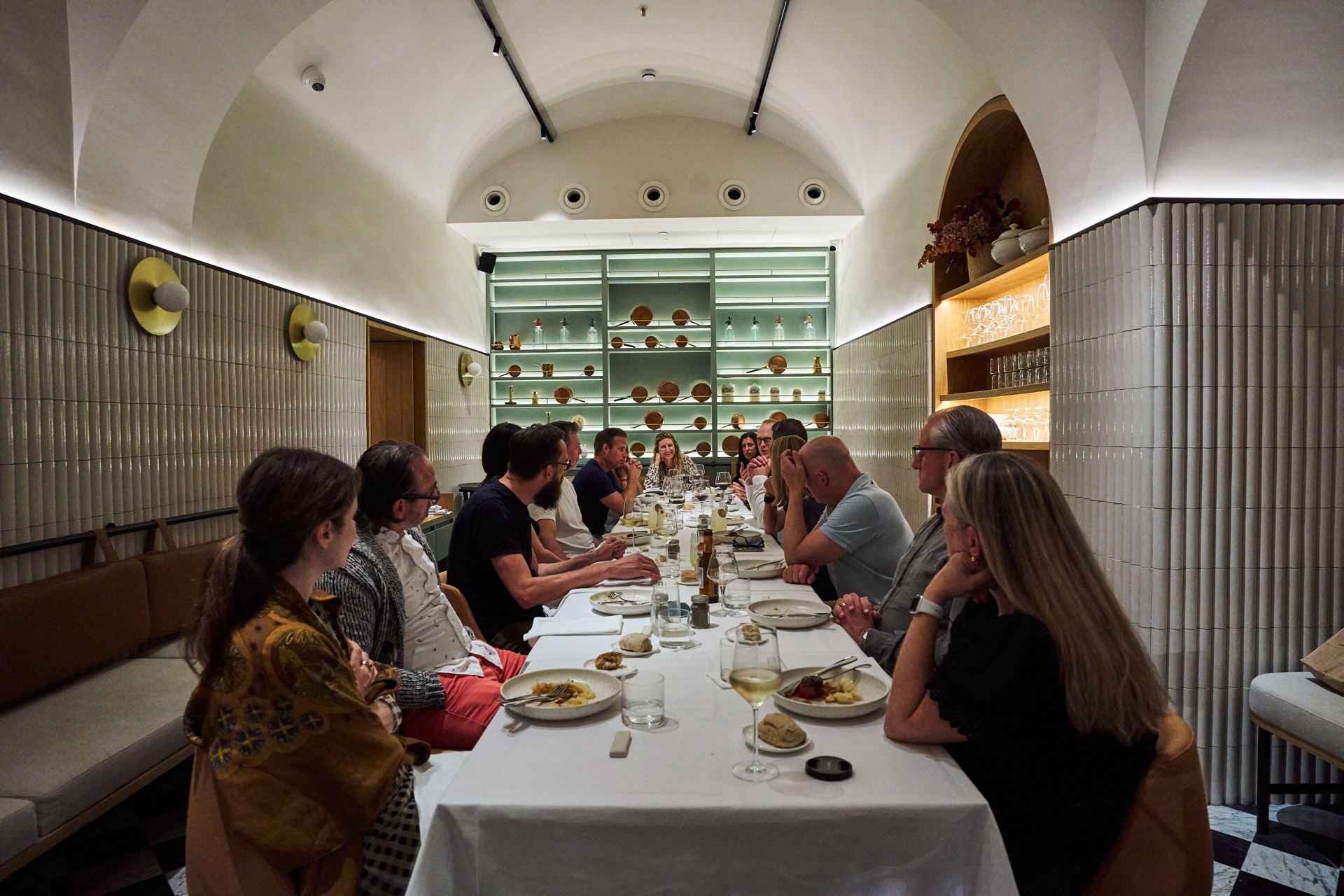 Long communal dinner in a vaulted stone dining room