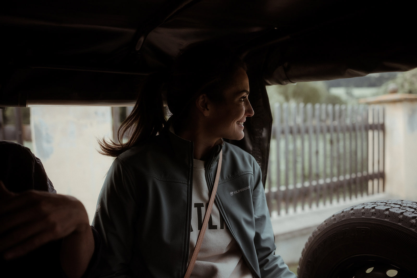 A participant smiling in the back of an open vehicle
