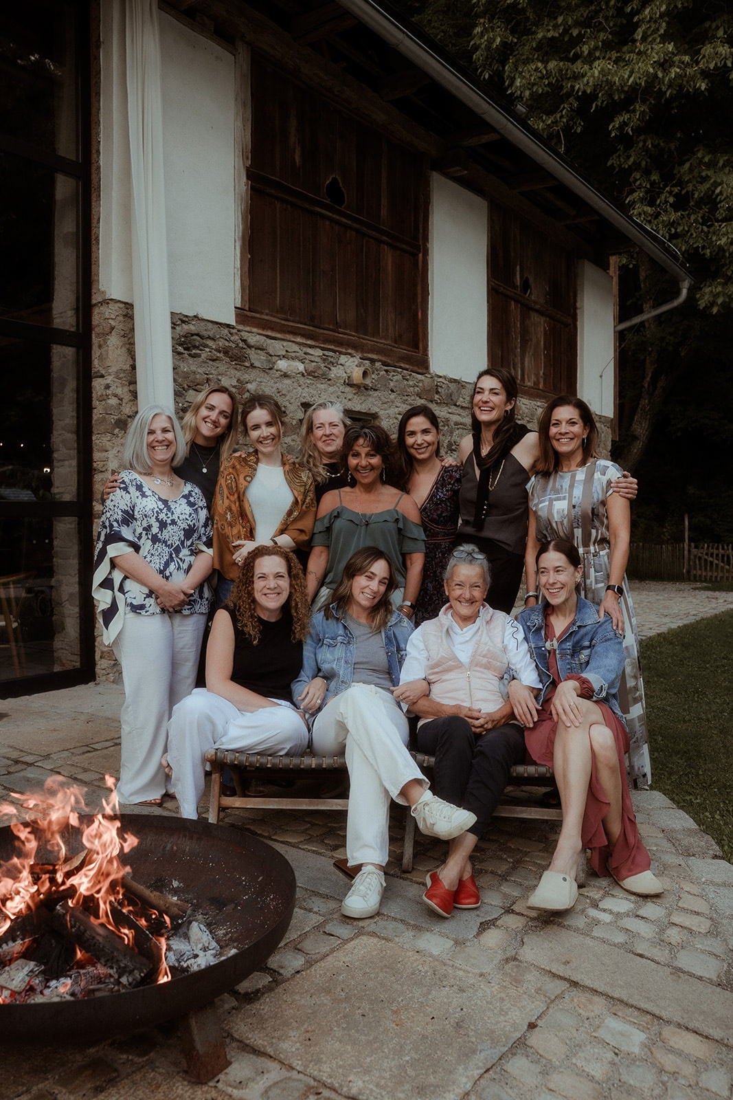 Group photo beside the fire pit outside the farmhouse