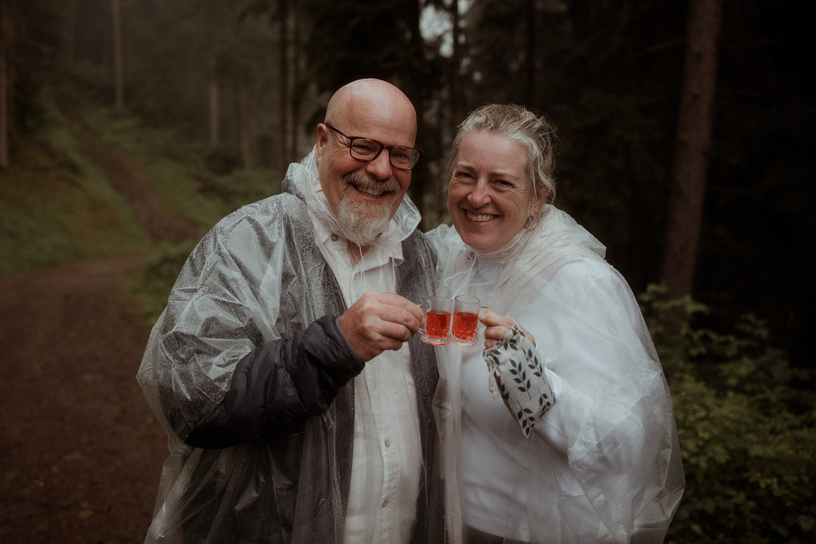 Two participants toasting with warm drinks in the woods