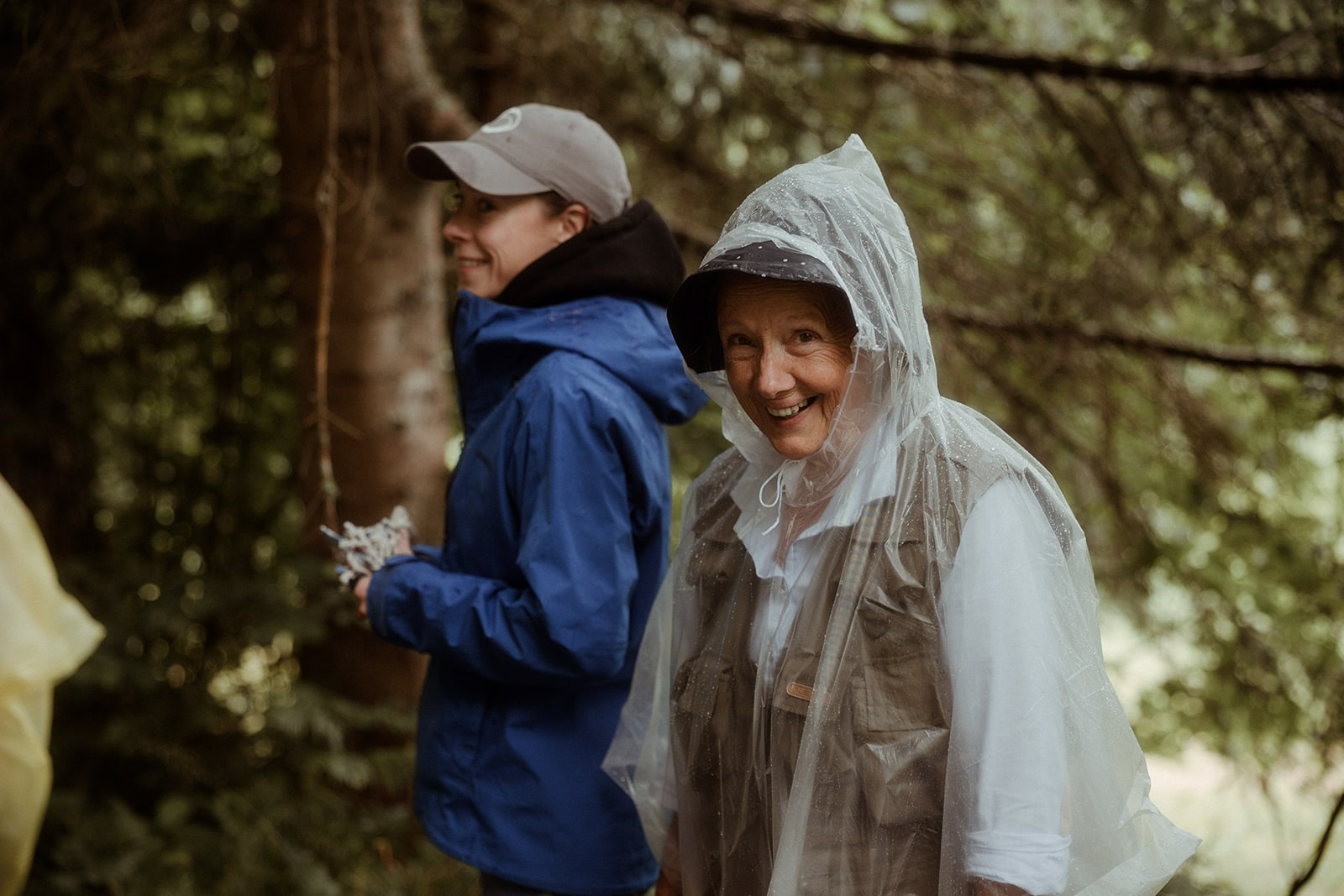 Two participants walking the forest trail in rain ponchos
