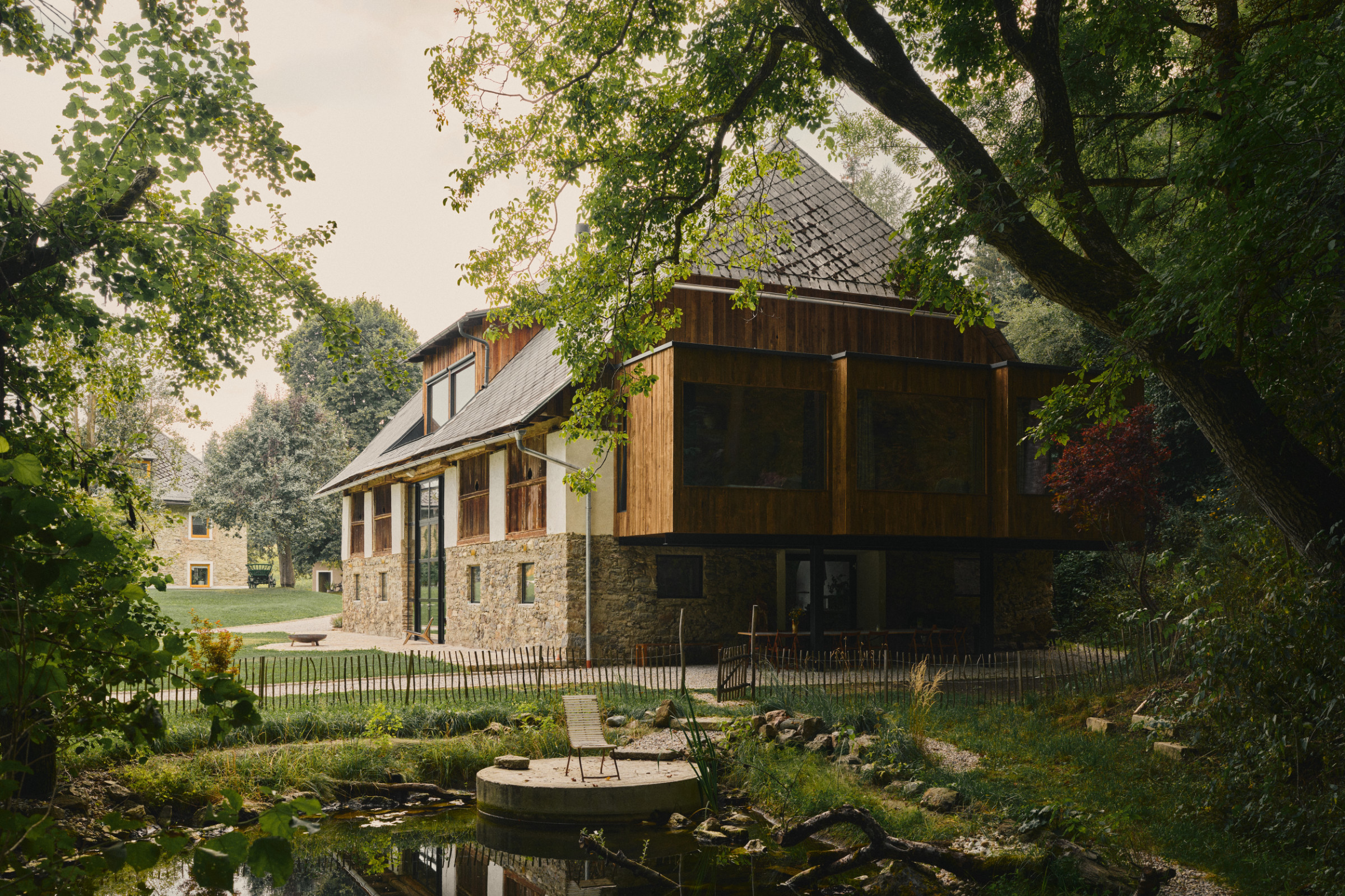 The restored stone farmhouse and pond in the Carinthian valley