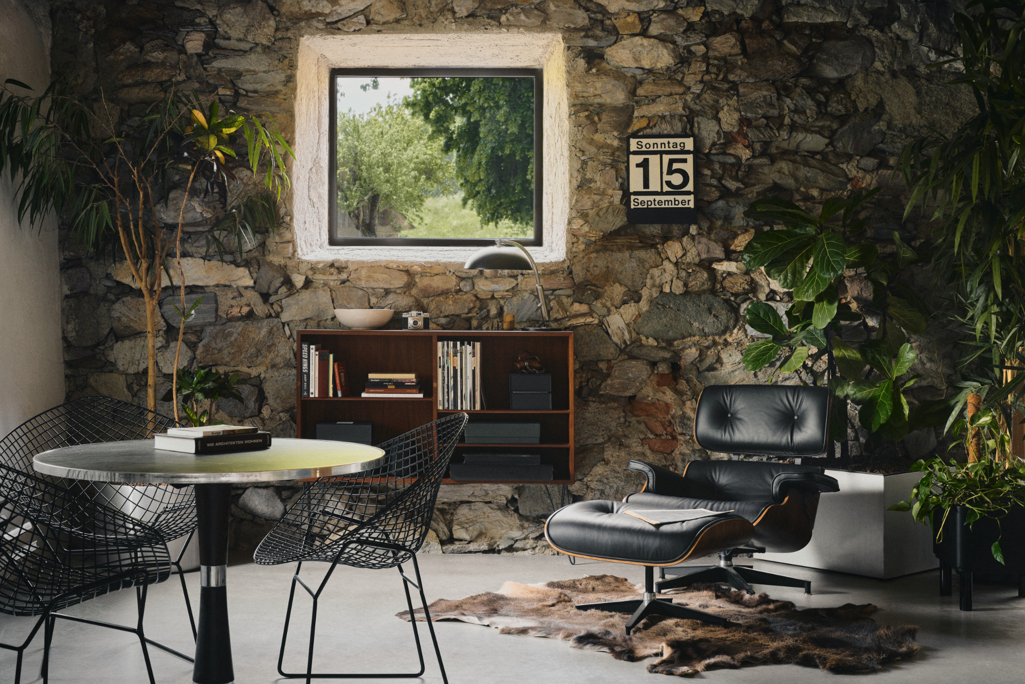 Stone-walled sitting room with a lounge chair and books