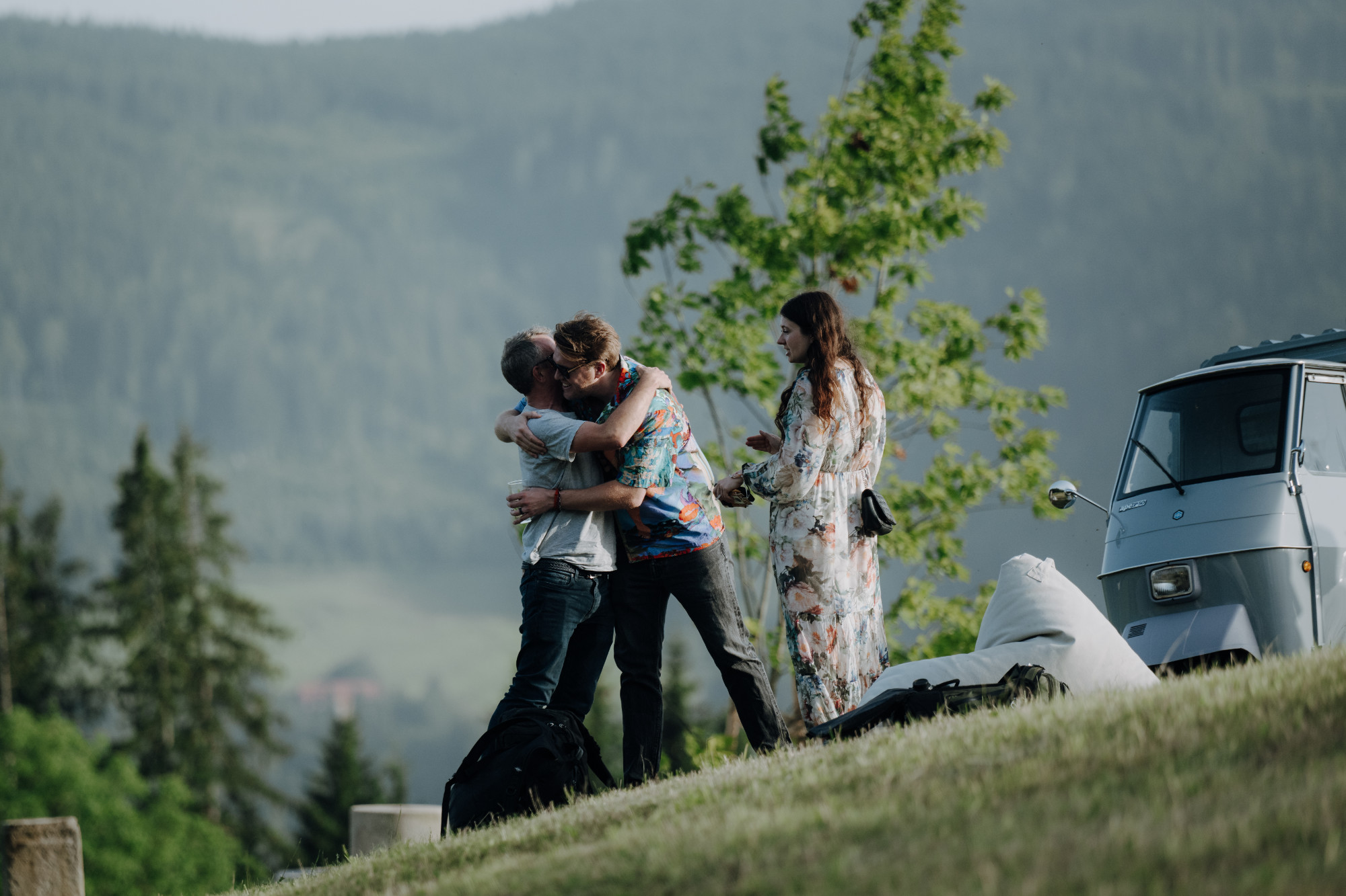 Two participants embracing on the hillside