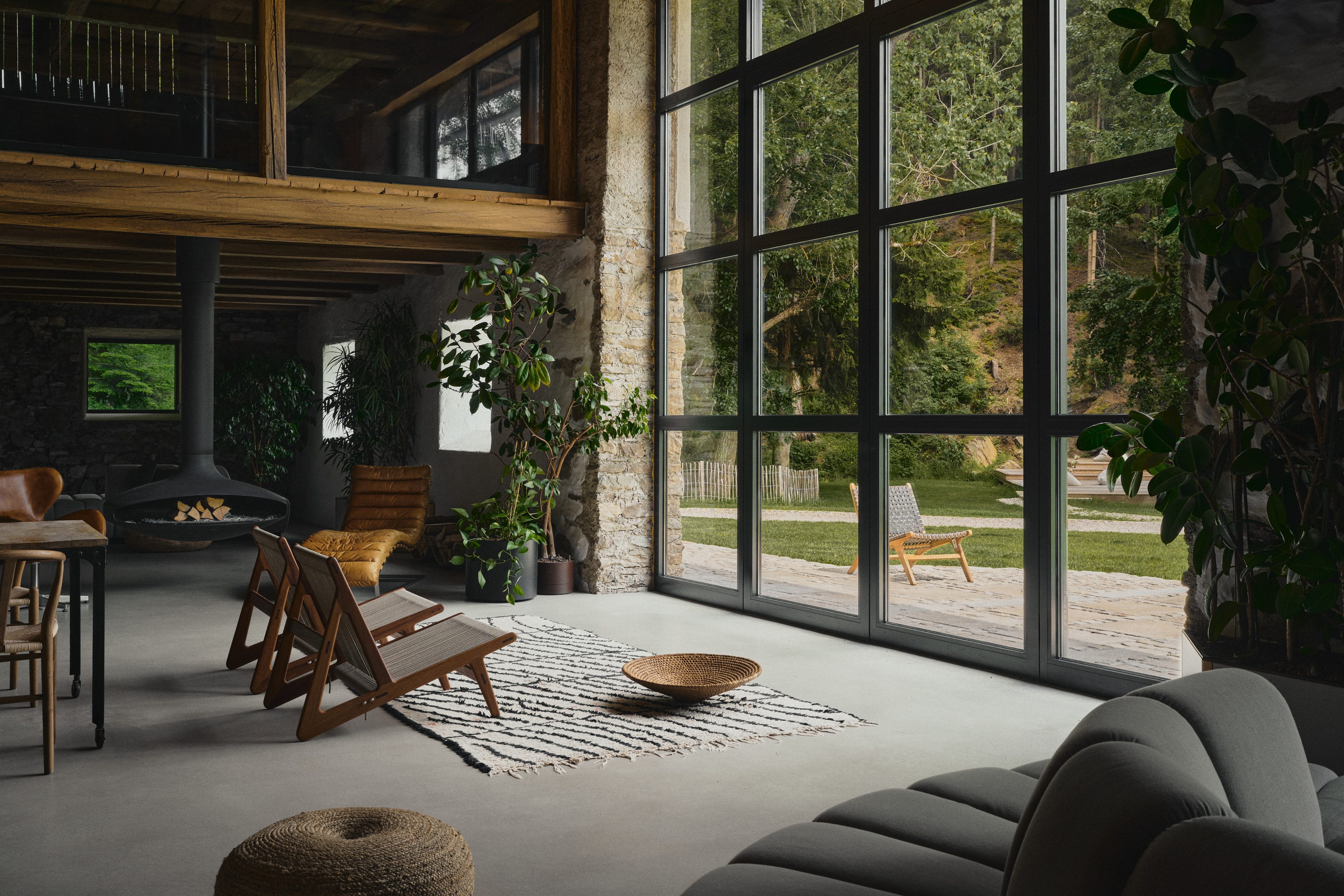 Barn lounge with tall windows looking onto the meadow