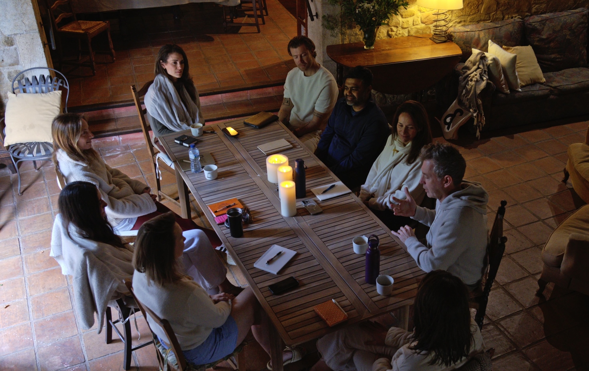 Evening group session around an outdoor table by candlelight