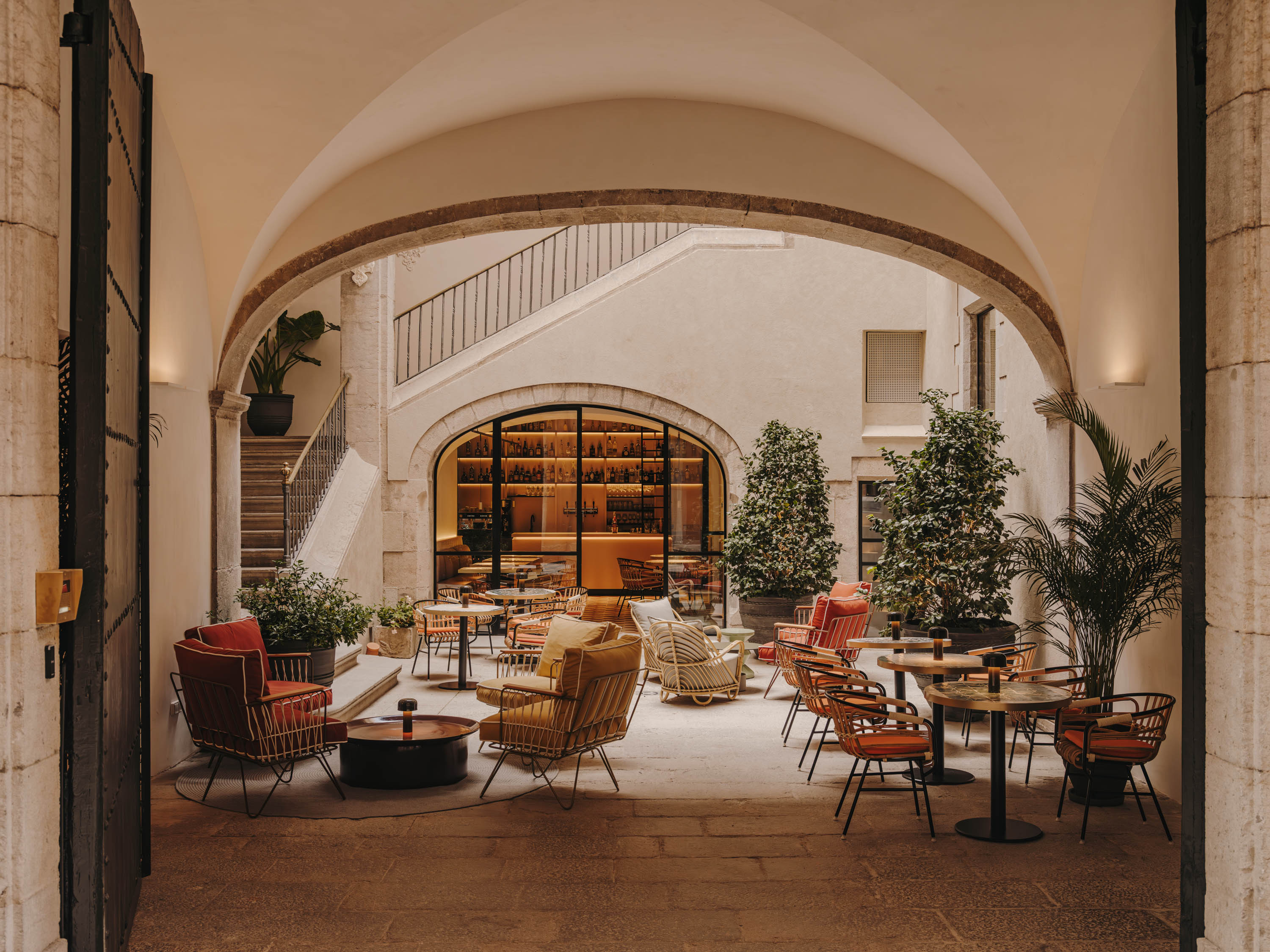 Arched garden room opening onto a courtyard with seating