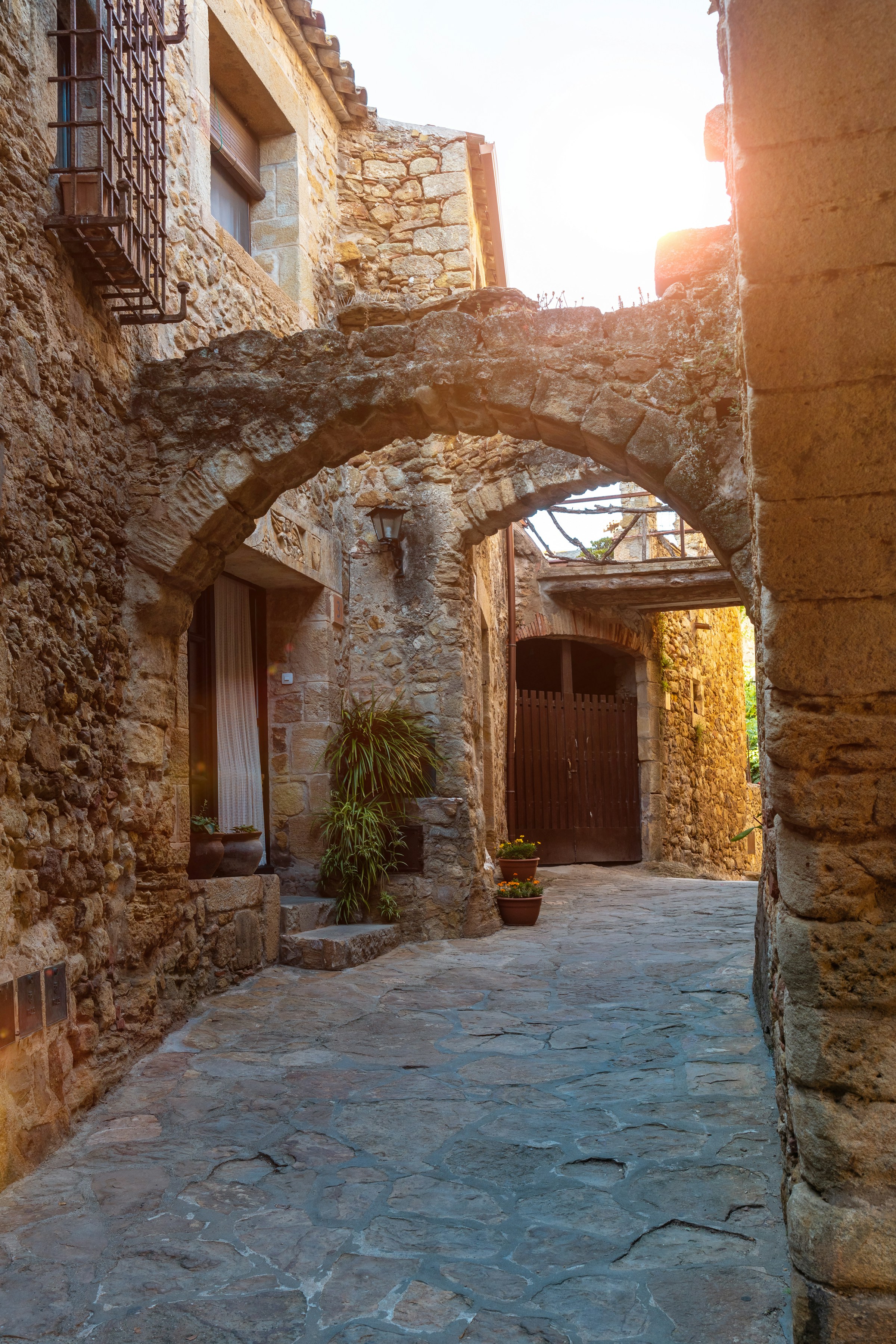 A stone archway in a village lane at golden hour