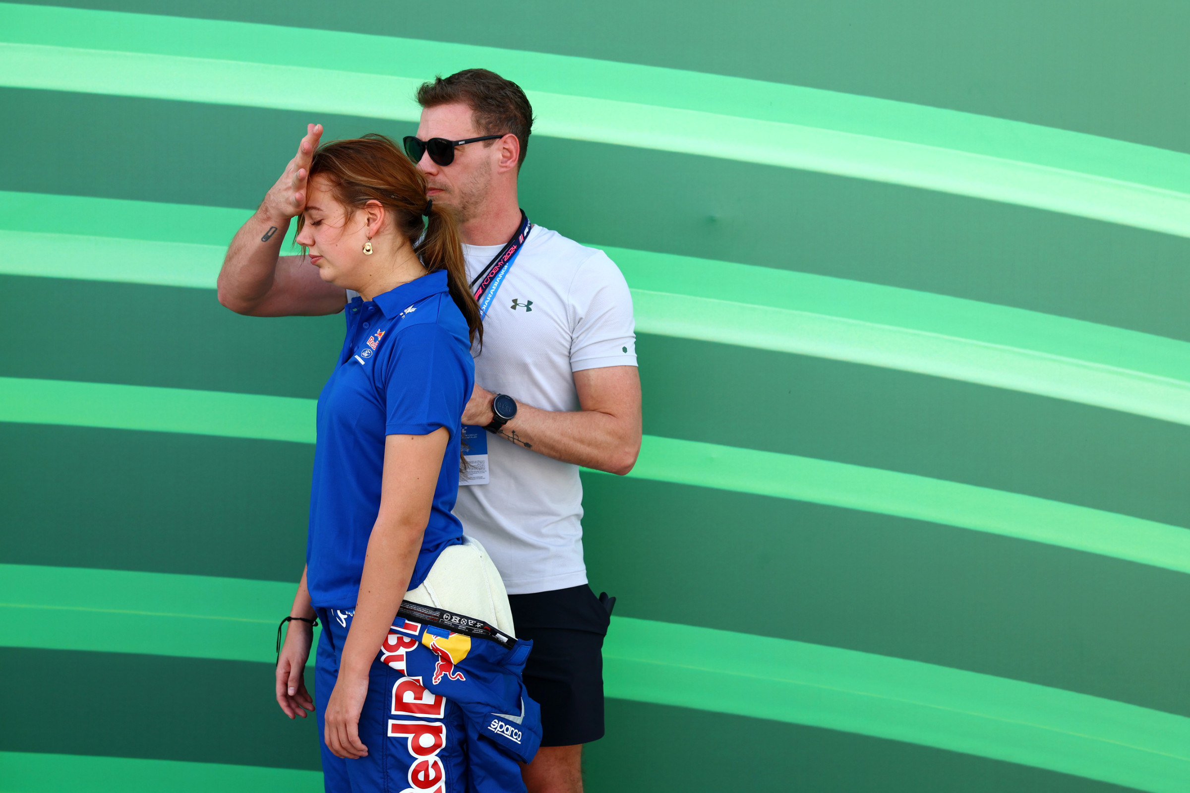 Two people talking in front of a bright green wall