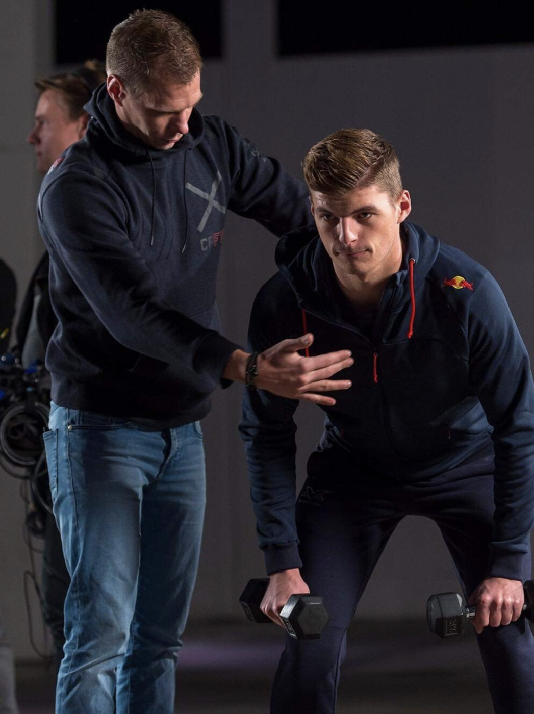 A coach working with an athlete in the gym