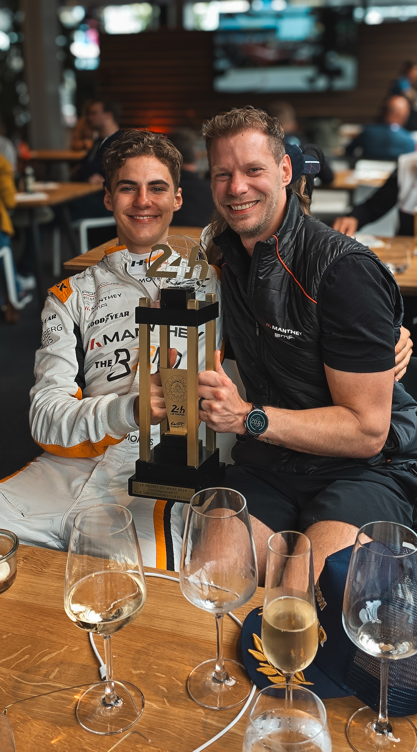 Two guests raising a trophy at a dinner table