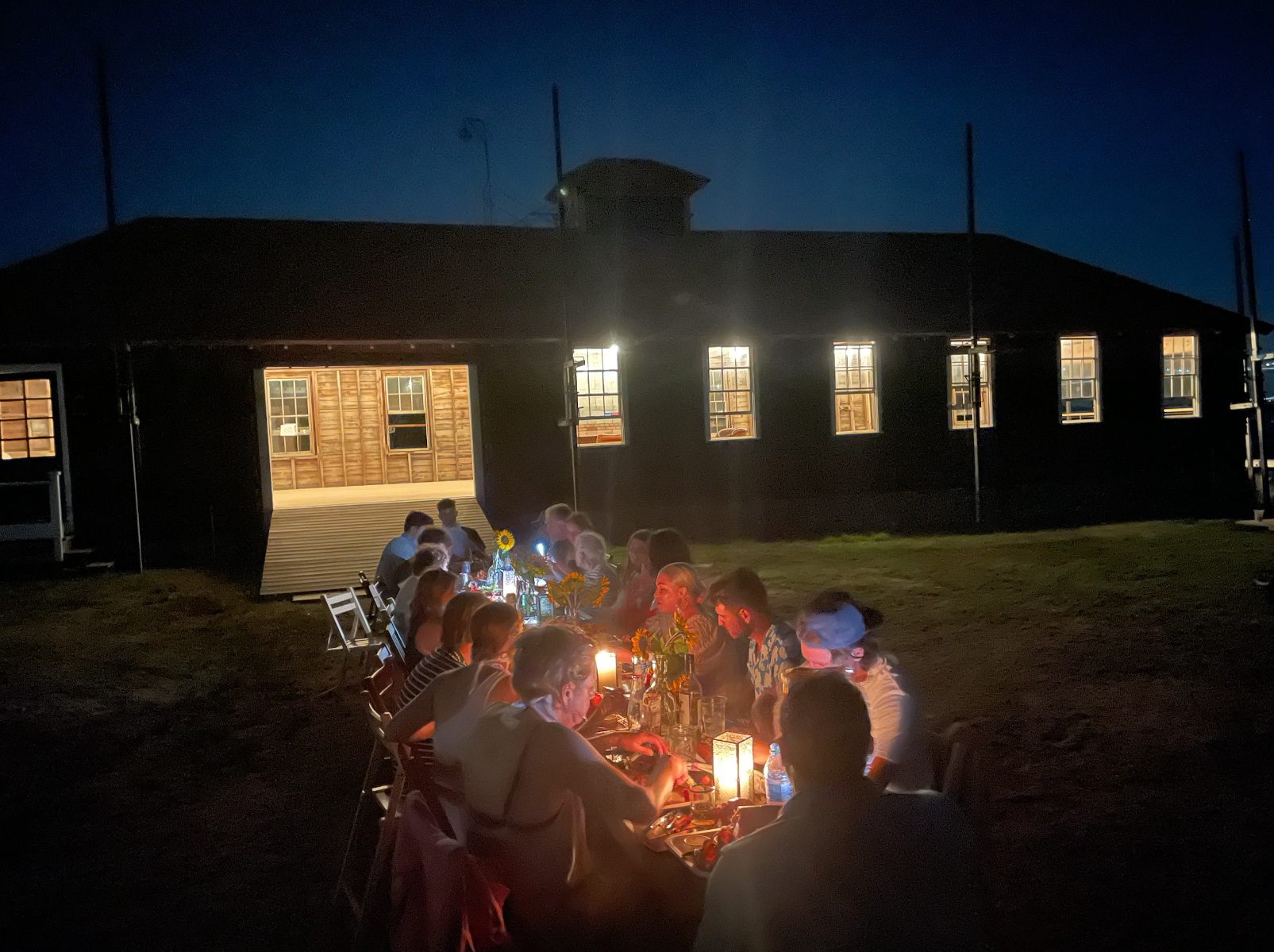 Candlelit dinner on the lawn outside the boathouse at night