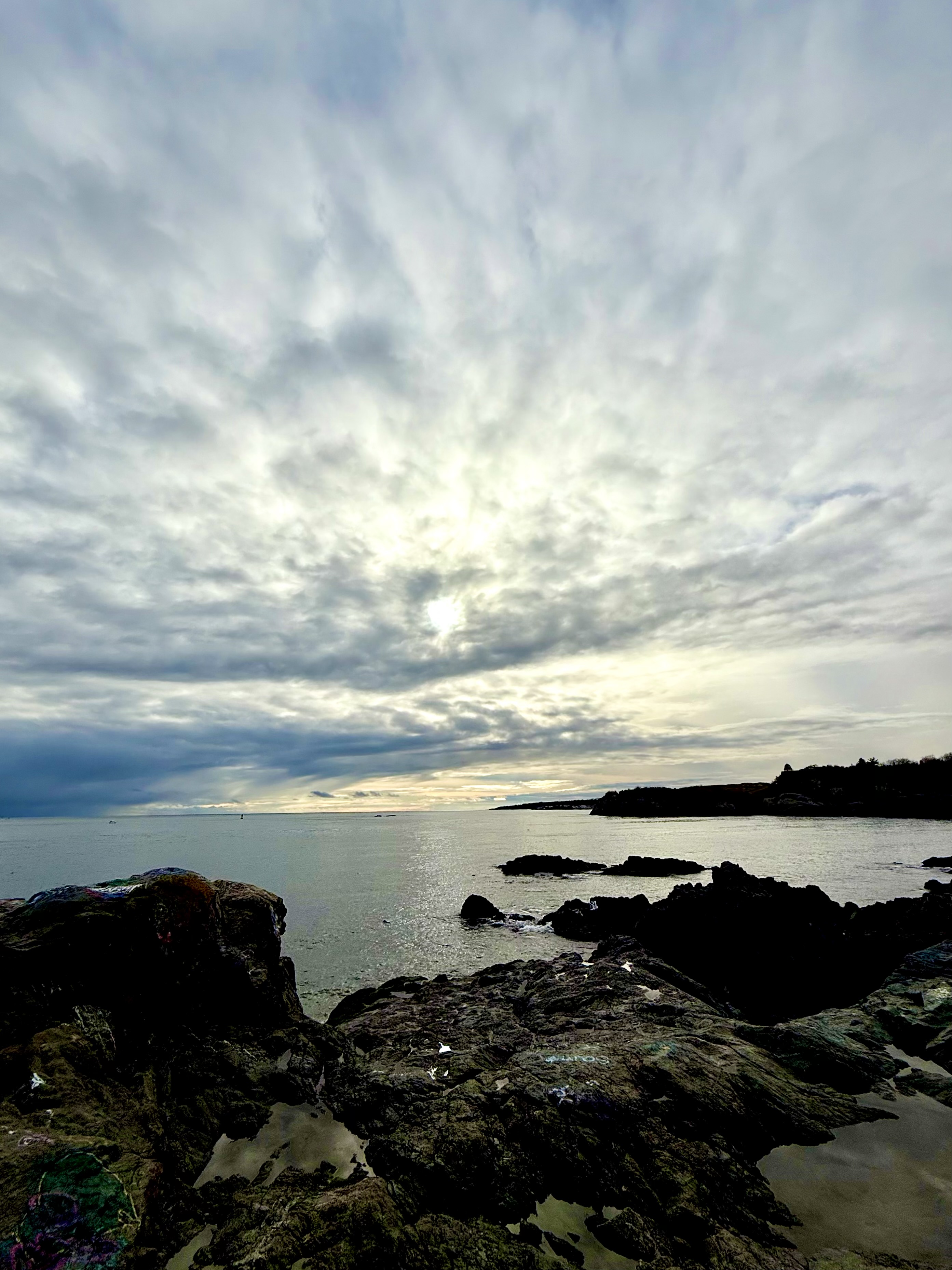 Waves breaking on rocks under a cloudy sky