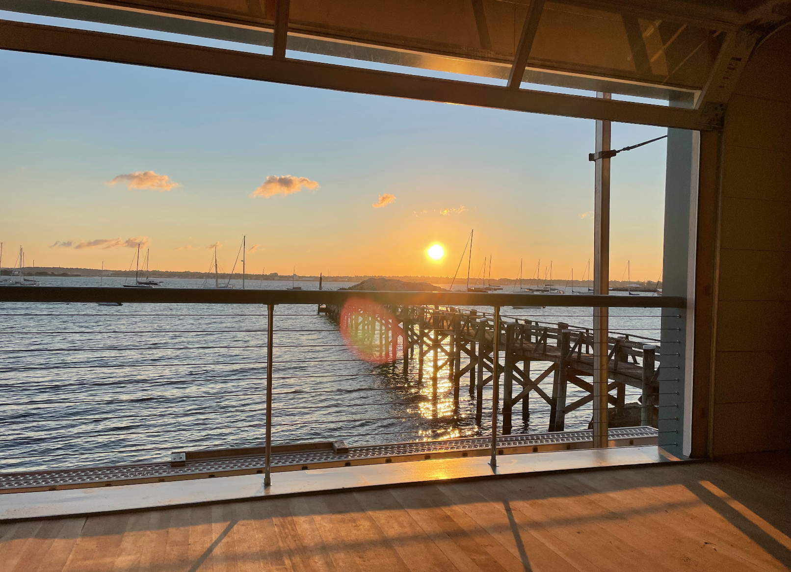 Sunset over the pier seen from inside the boathouse