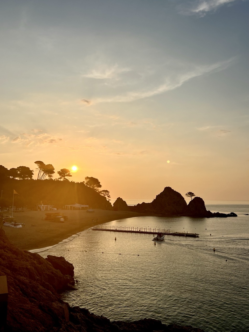 Sunset over the bay with rocks in the foreground
