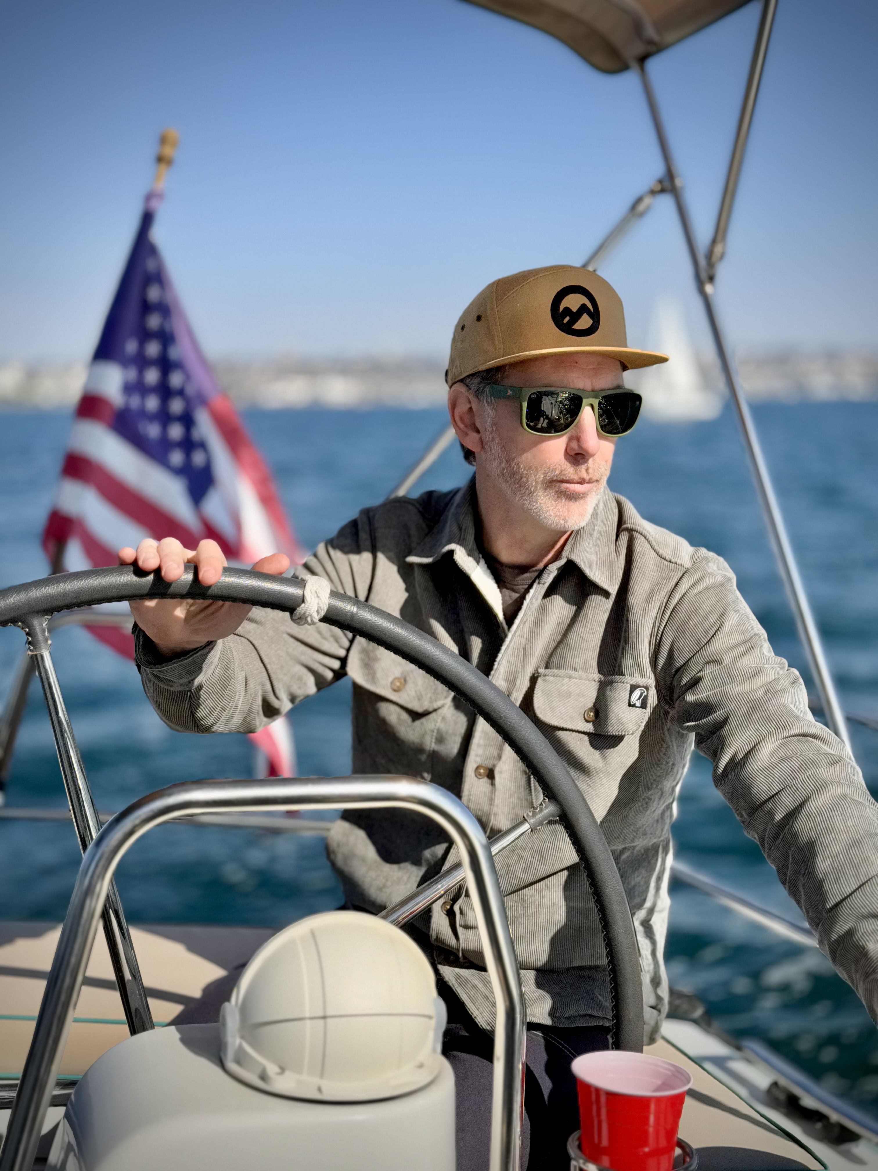 A participant at the helm of a boat with the US flag behind