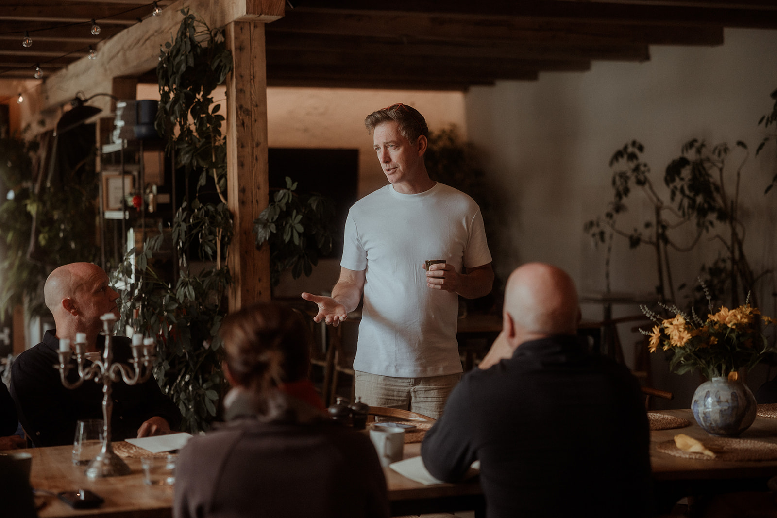 A participant speaking to the group at dinner in the barn