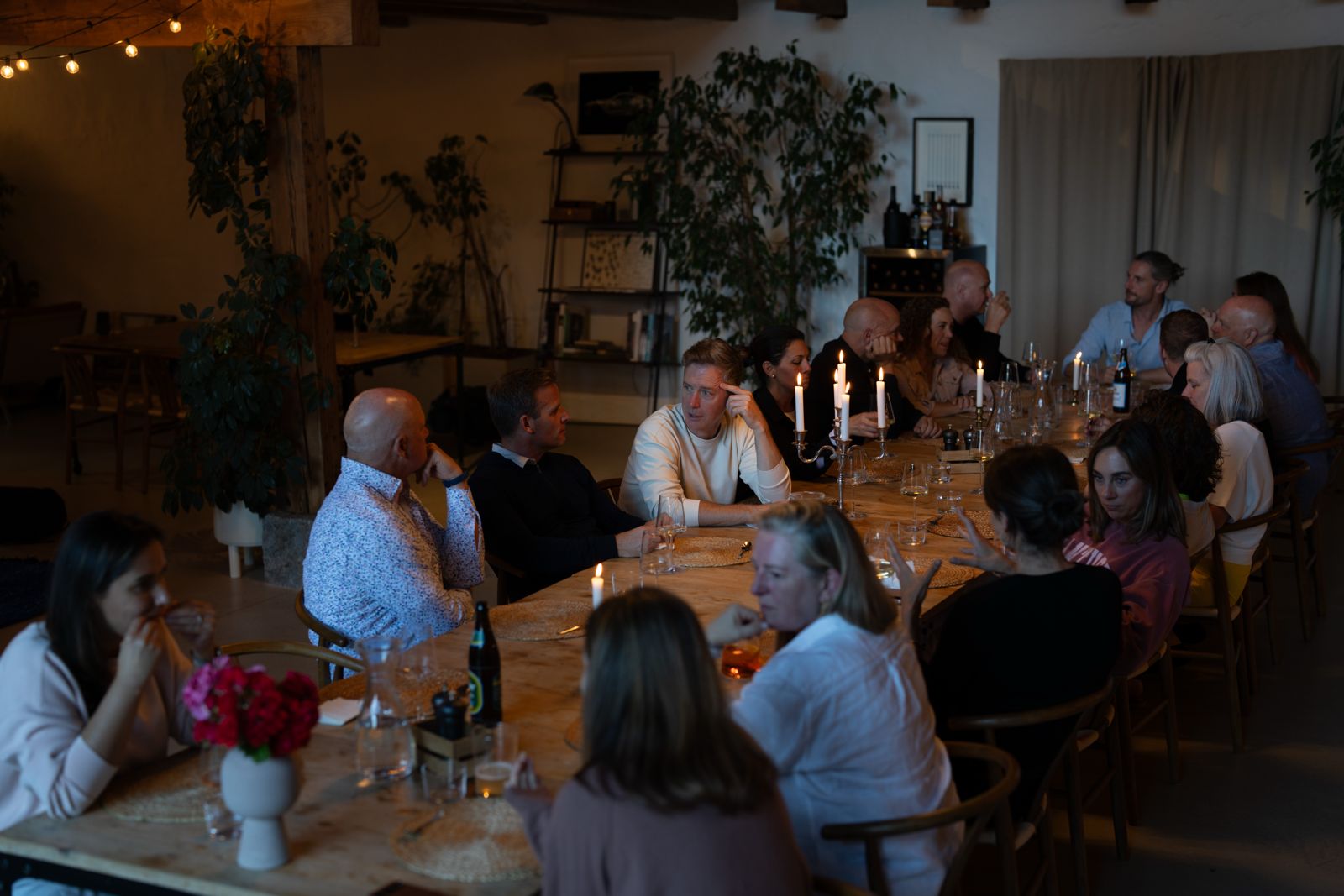 Long candlelit table with the group in conversation