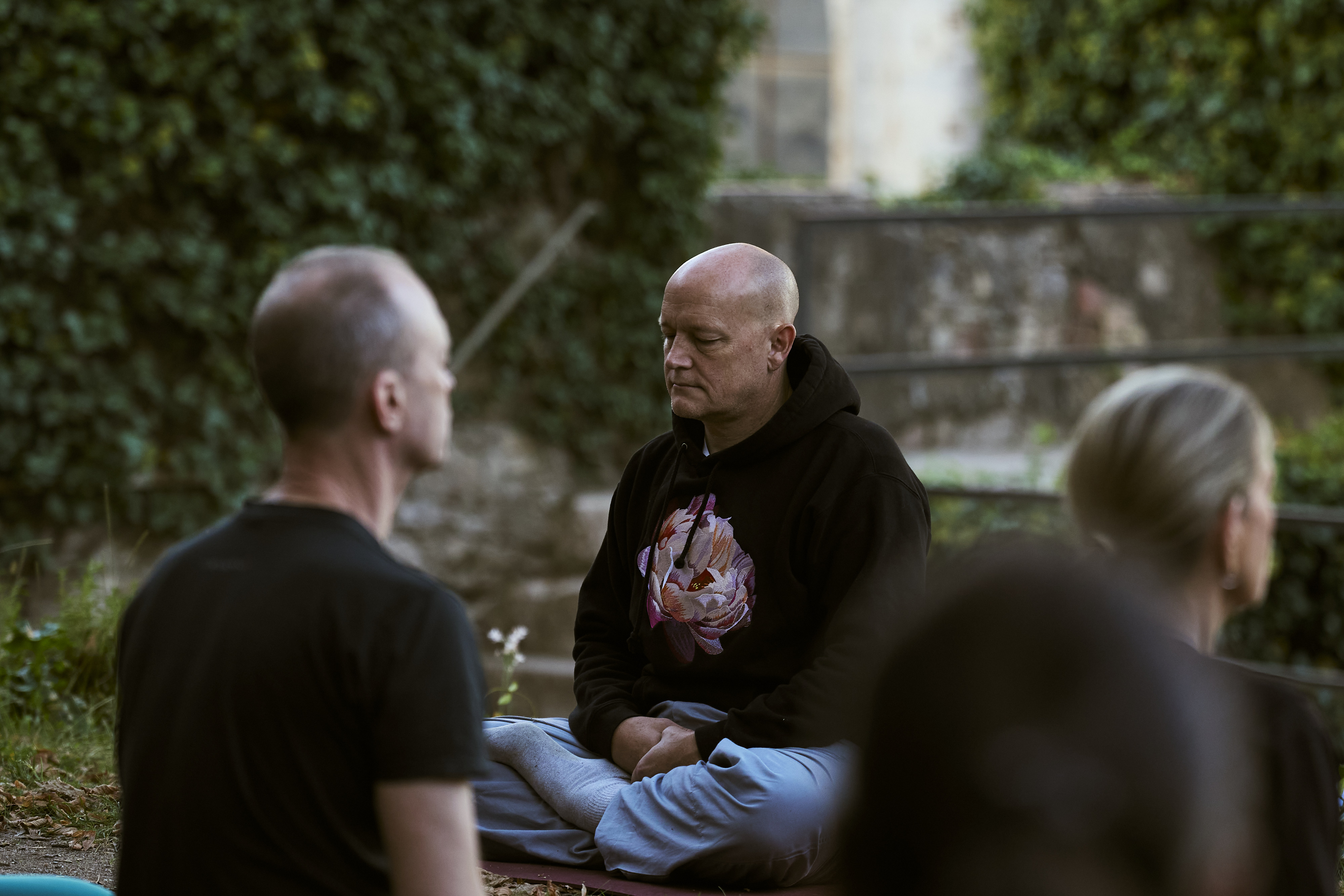 Two participants talking in a garden at dusk