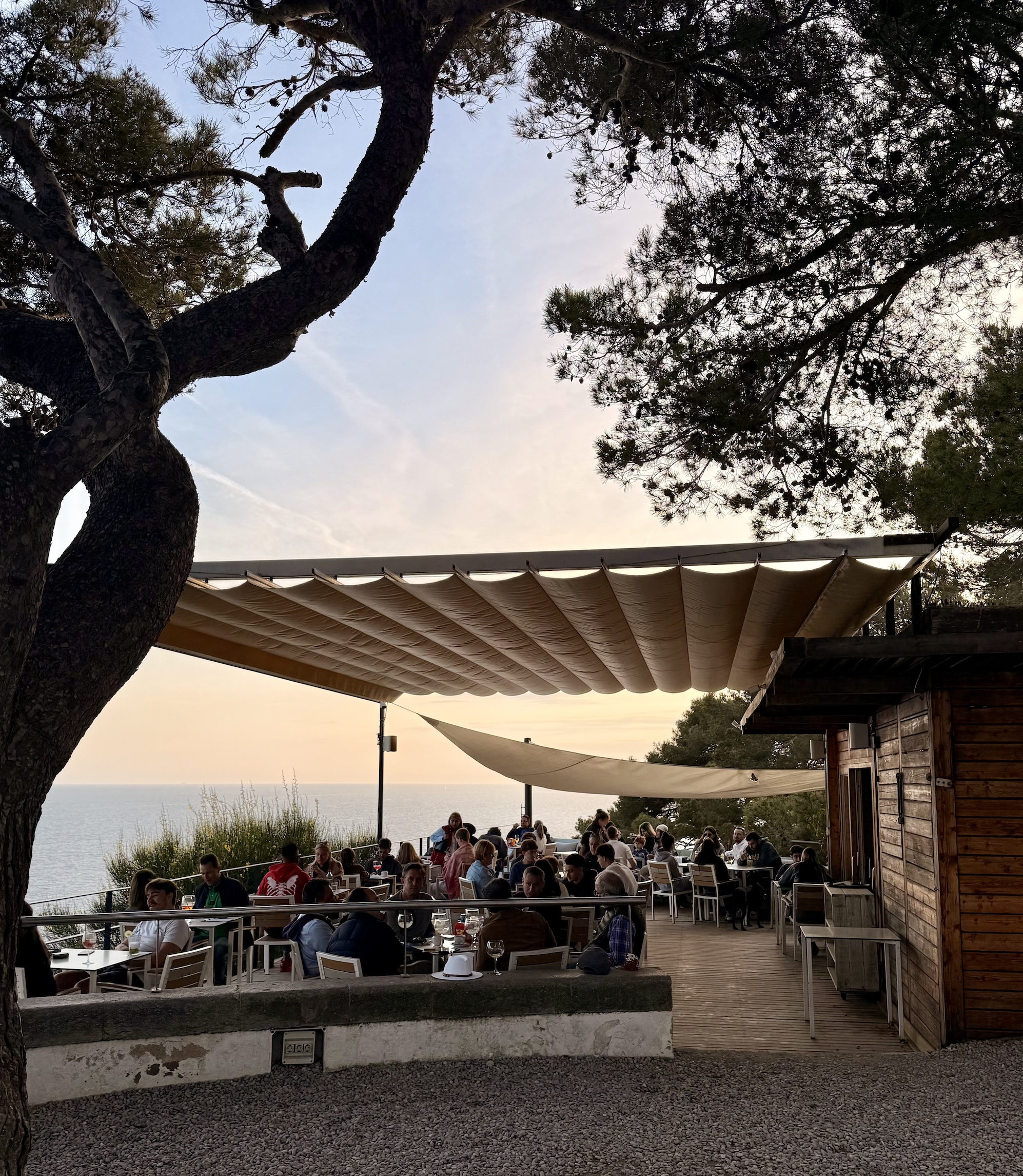 A terrace restaurant looking out to the sea at sunset