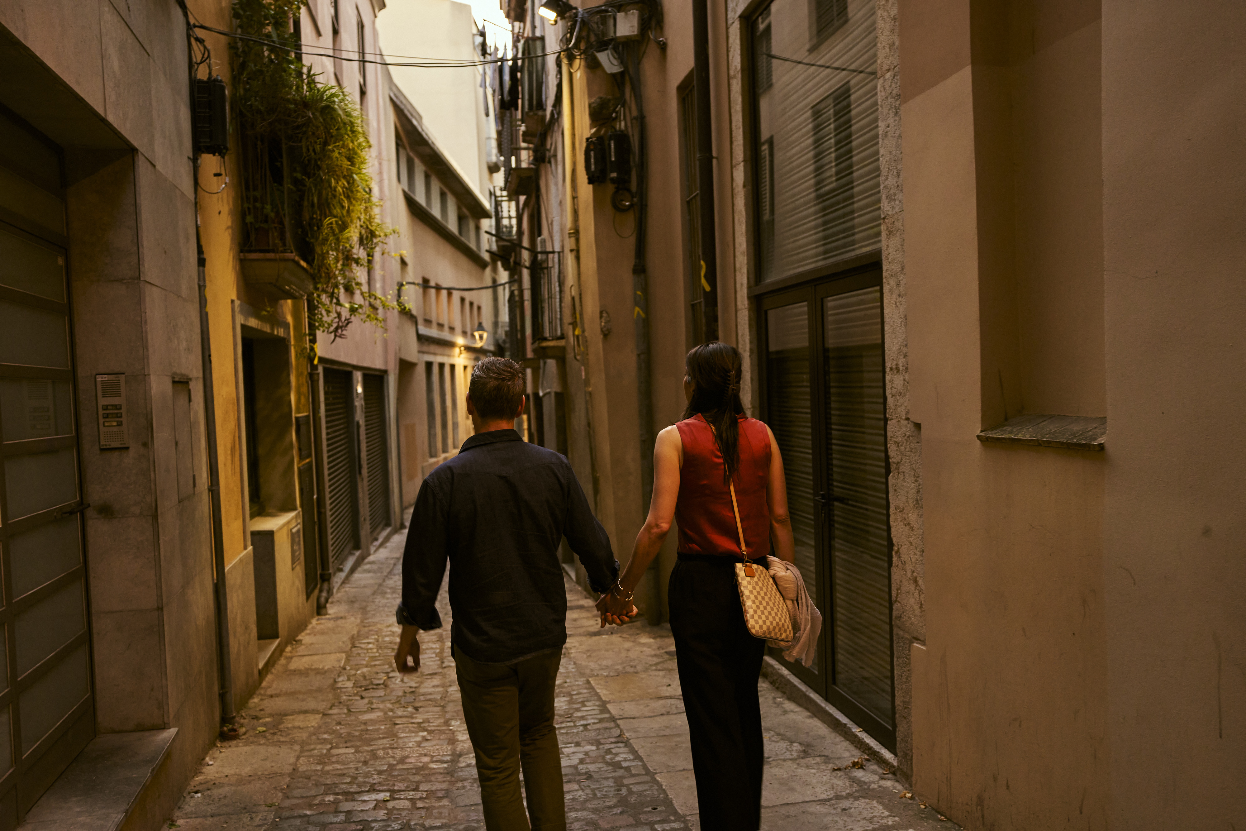 A narrow old-town street with two people walking