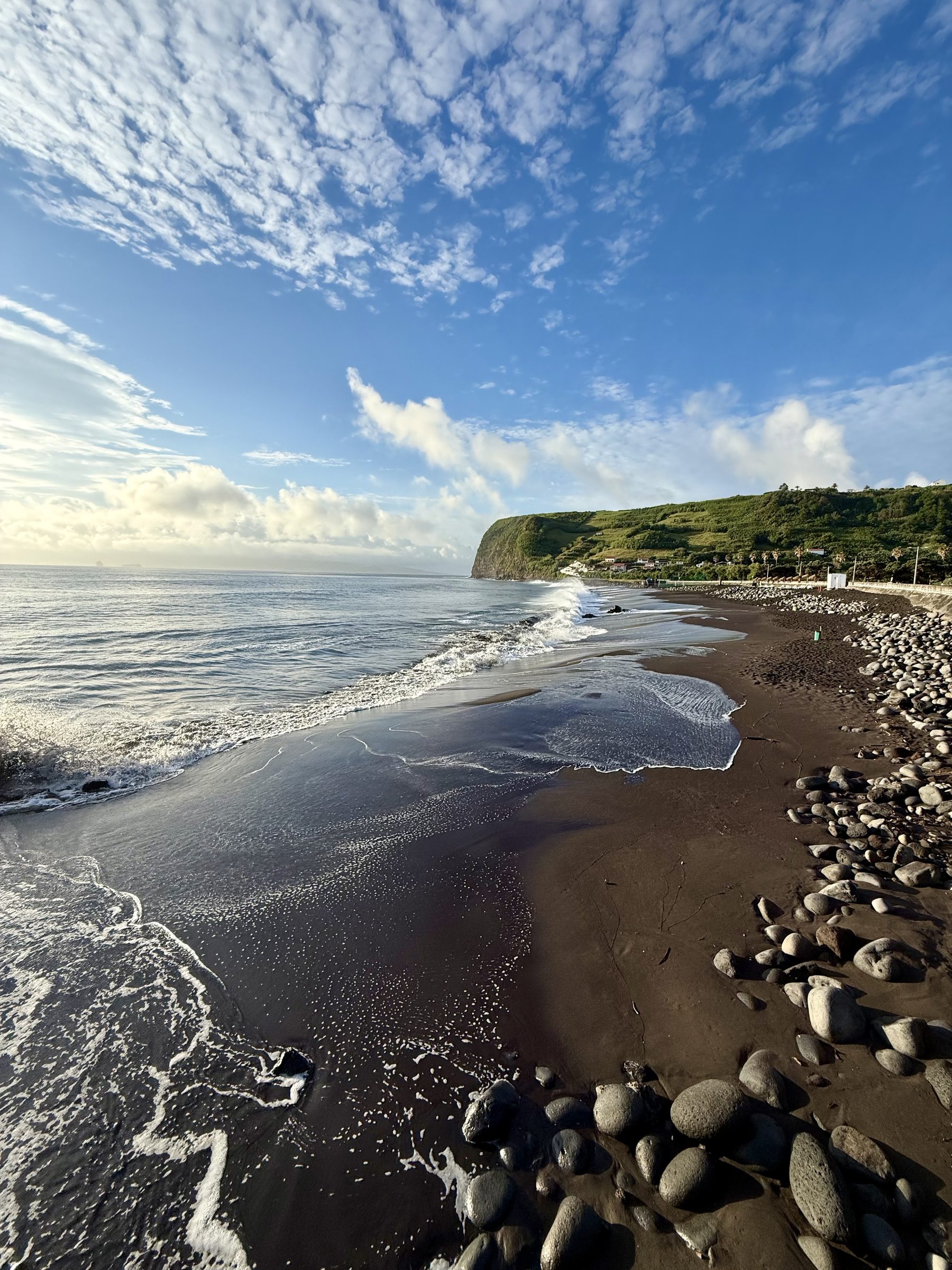 Surf washing over the black sand at Praia do Almoxarife