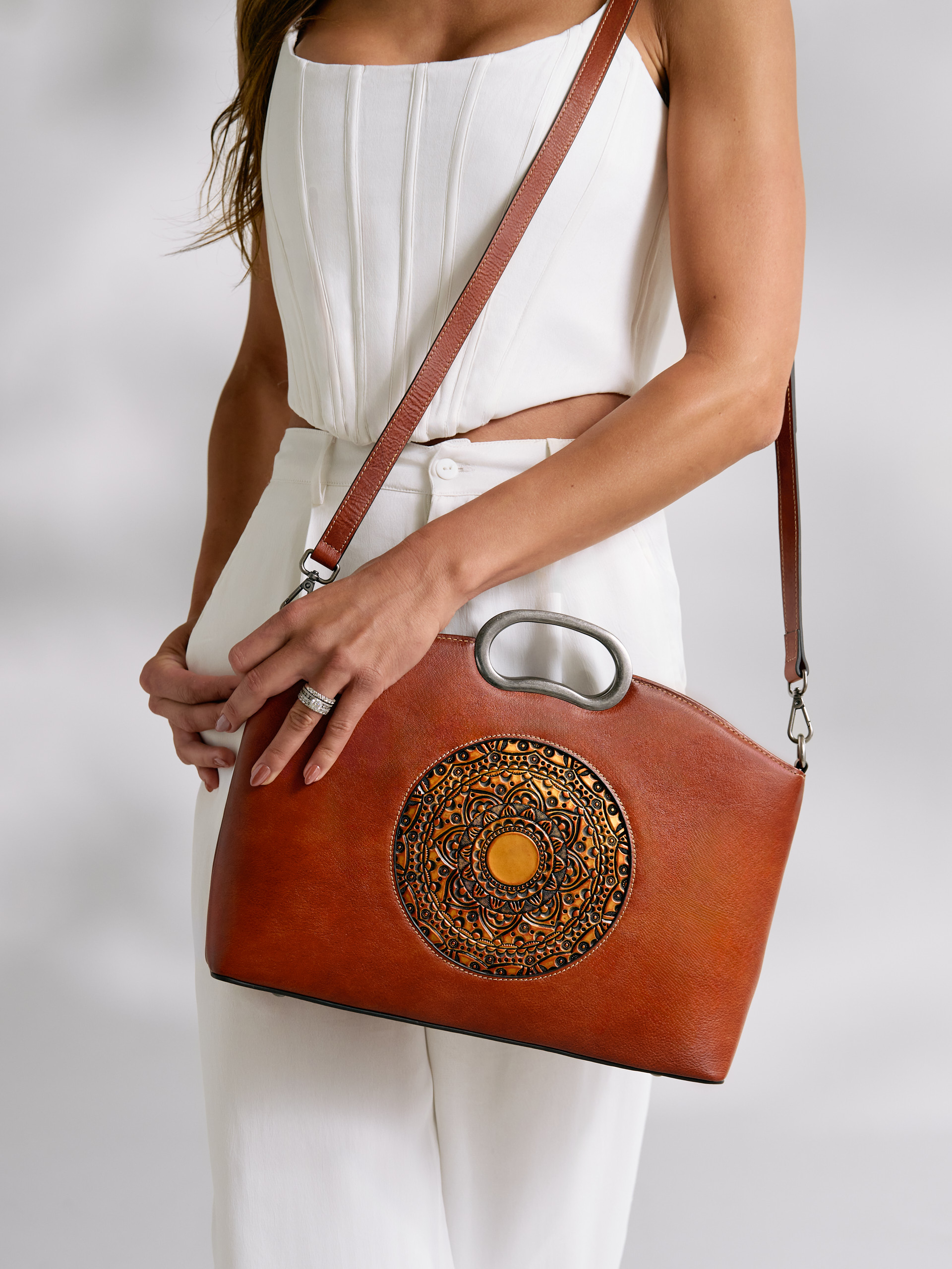 Fashion accessories including handbags and jewelry styled on a model, photographed with clean lighting for e-commerce and catalog use.
