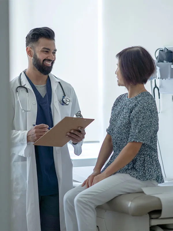 A doctor standing with a patient discussing their clinic visit.