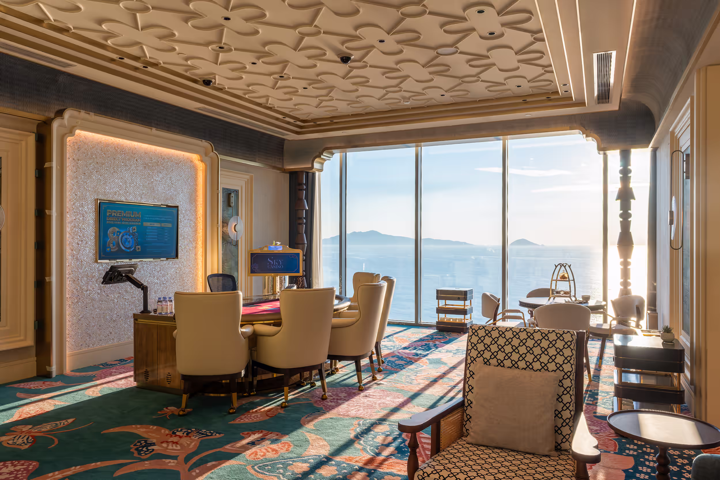 Private gaming suite at Sky Casino with a Baccarat table, lounge seating and floor-to-ceiling sea views.
