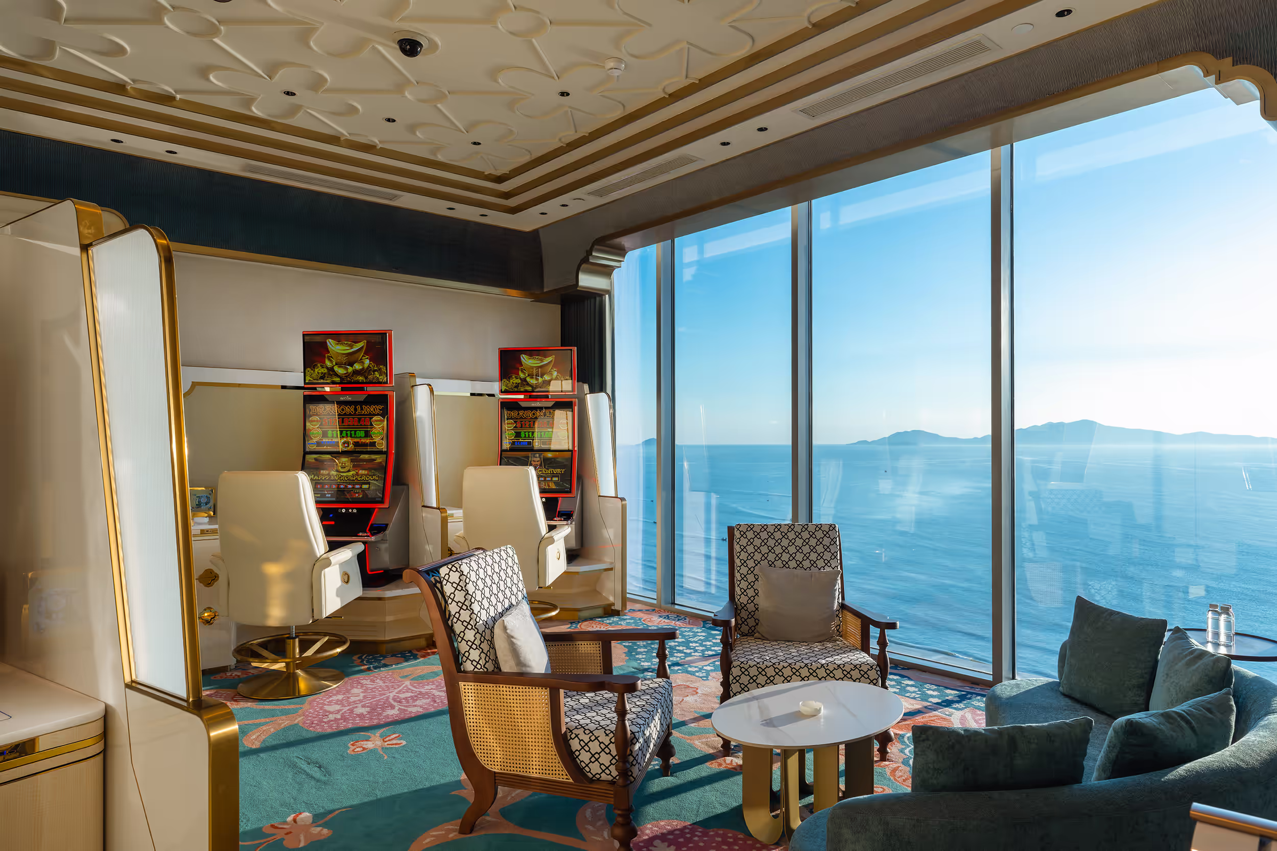Private slot lounge at Sky Casino with two gaming machines, plush armchairs and panoramic sea views.
