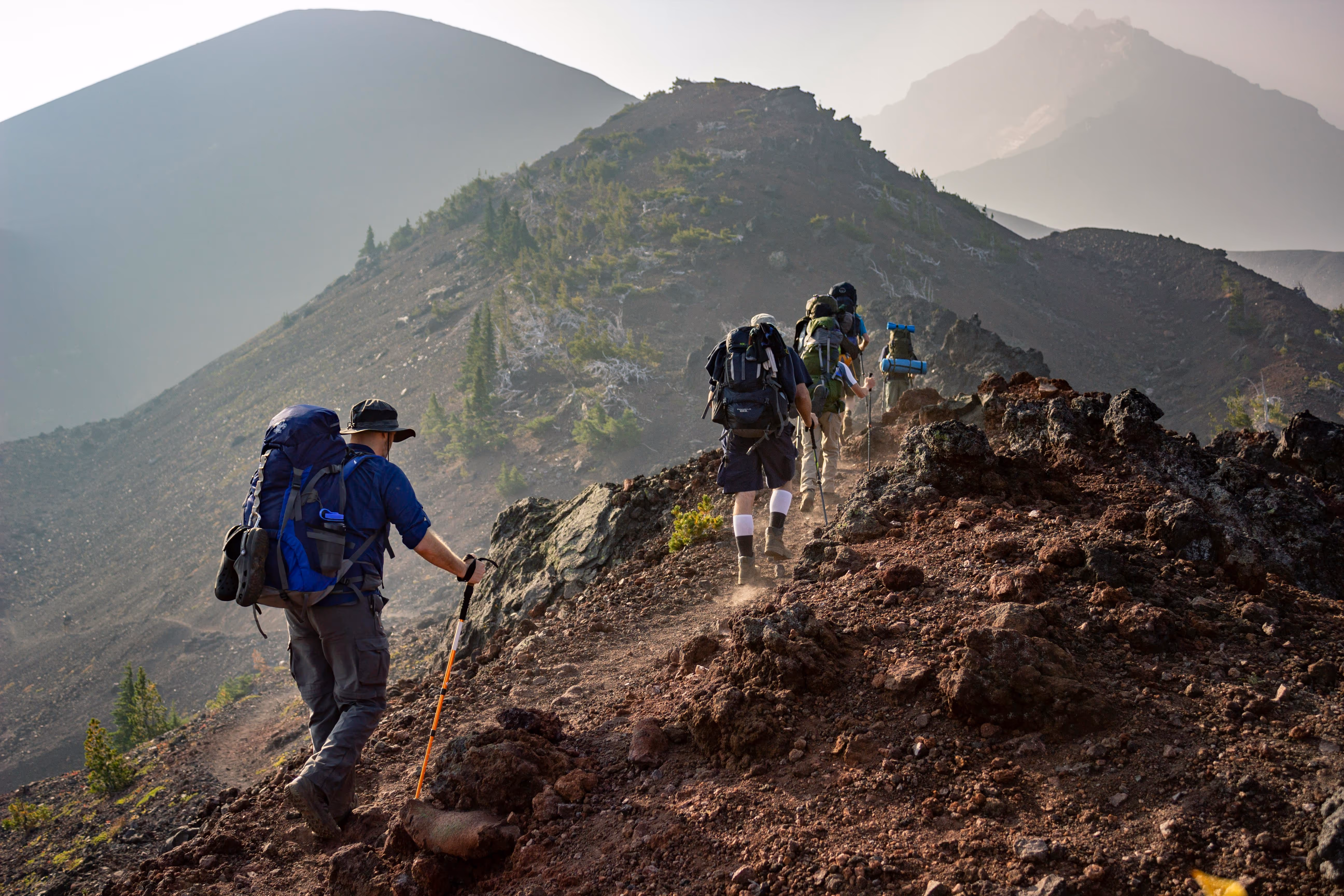 3 personnes gravissant une montagne. Ici pour symboliser le progrès.